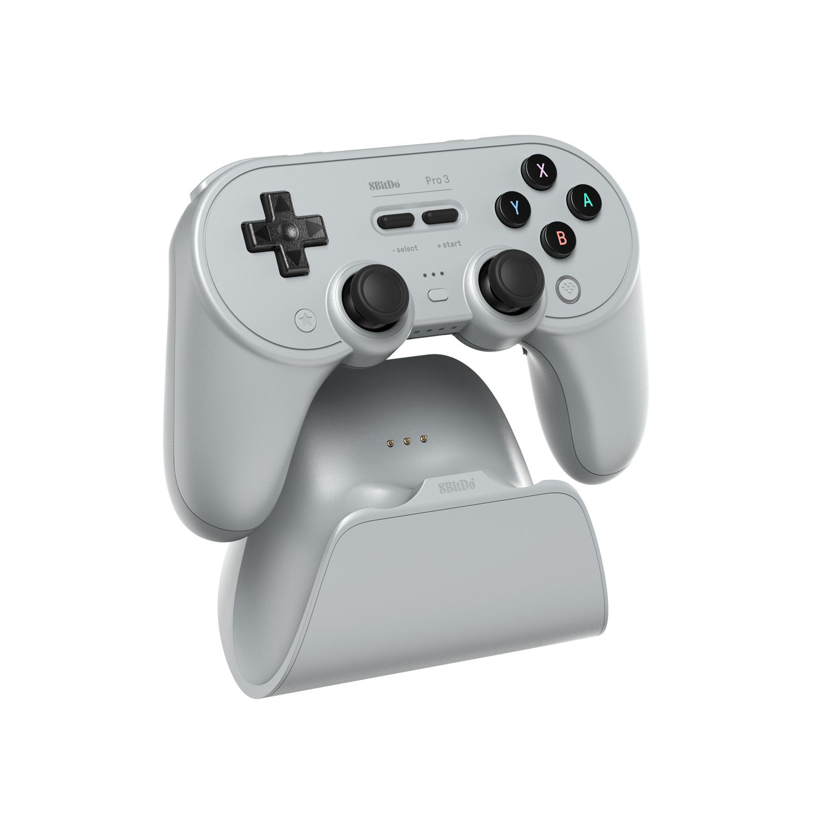 Grauer 8BitDo Pro 3-Gamepad und Ladestation, isoliert auf weißem Hintergrund. Tasten sind X, Y, A, B und ein Steuerkreuz.