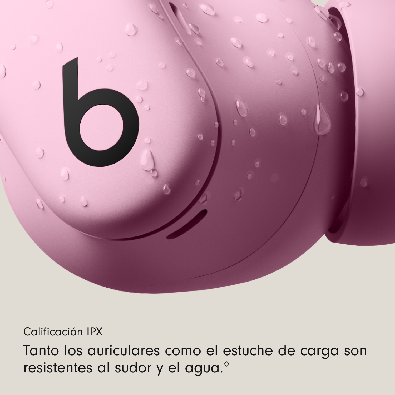 Primer plano de auriculares rosas con gotas de agua. Visible la letra 'b' en negro. El texto indica que los auriculares son resistentes al sudor y al agua.