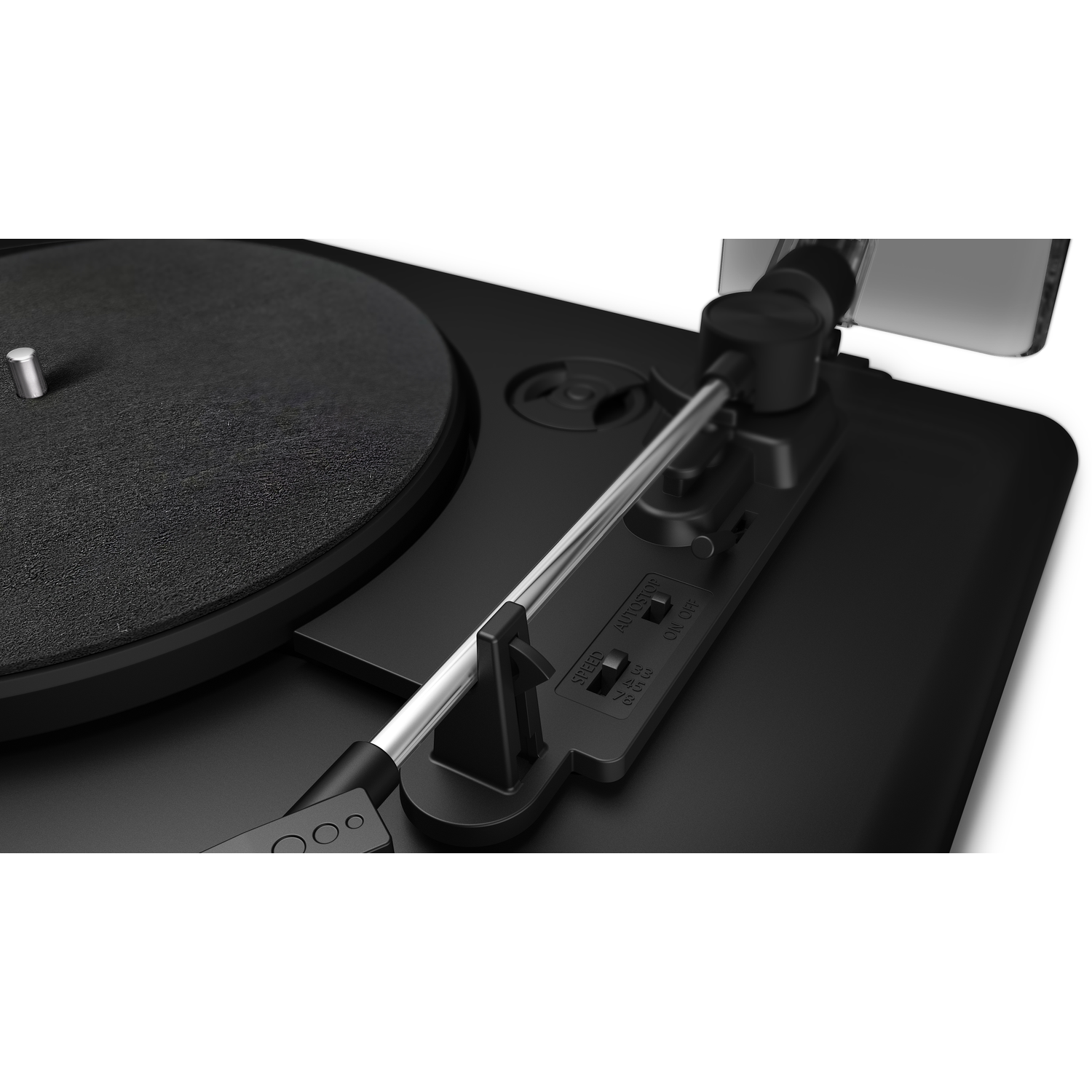Close-up of a black turntable. The needle arm is silver. Controls include speed and on/off. The record surface is textured.
