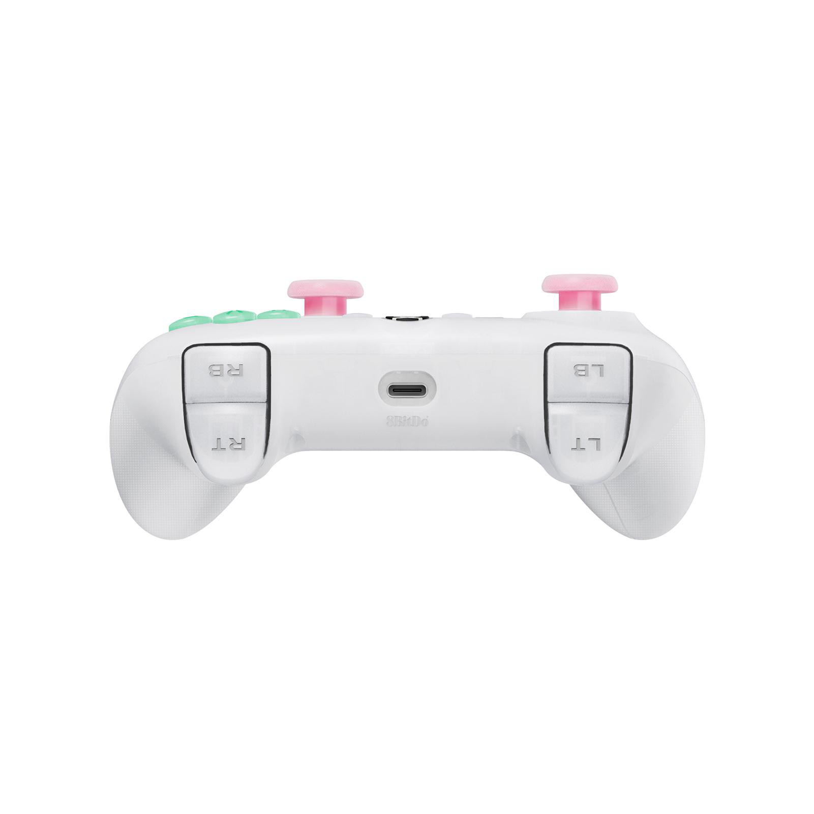 Weißer Controller mit rosa und grünen Knöpfen und rosa Joysticks, nach vorne auf weißem Hintergrund.
