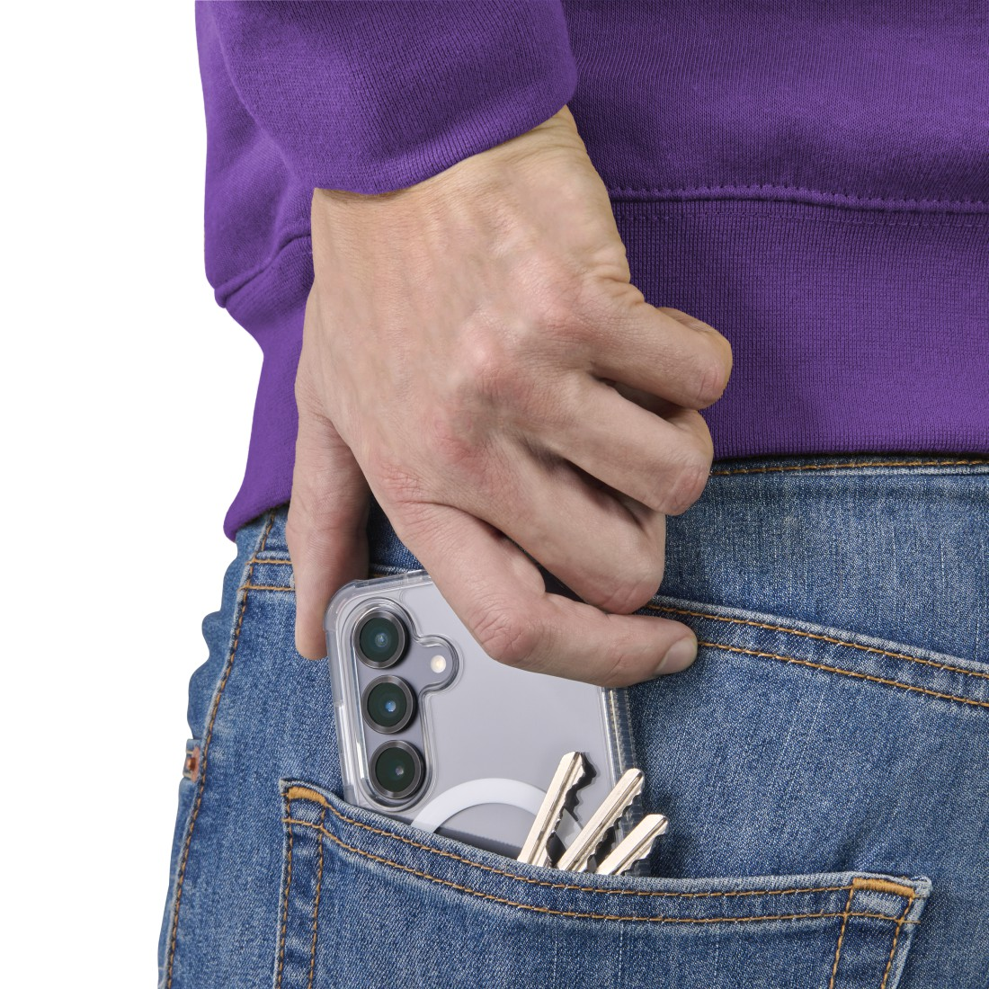 Eine Hand in einem lila Pullover steckt ein Telefon in eine Jeans-Tasche. Auch Schlüssel sind in der Tasche. Das Telefon hat drei Kameras.