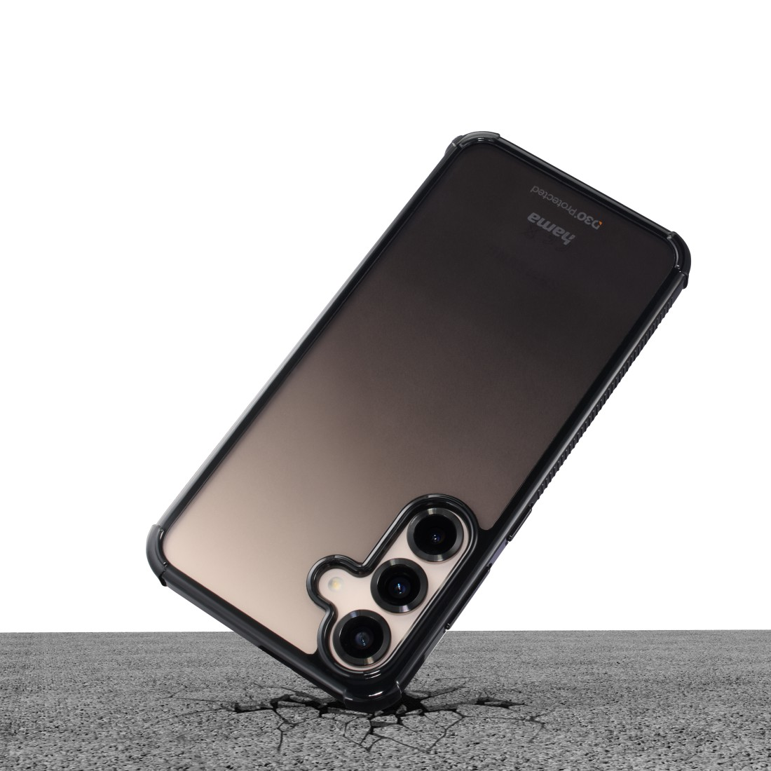 Ein Telefon in einer schwarzen Hülle fällt auf eine gerissene Betonoberfläche. Das Telefon ist angewinkelt und zeigt die Kameralinsen.