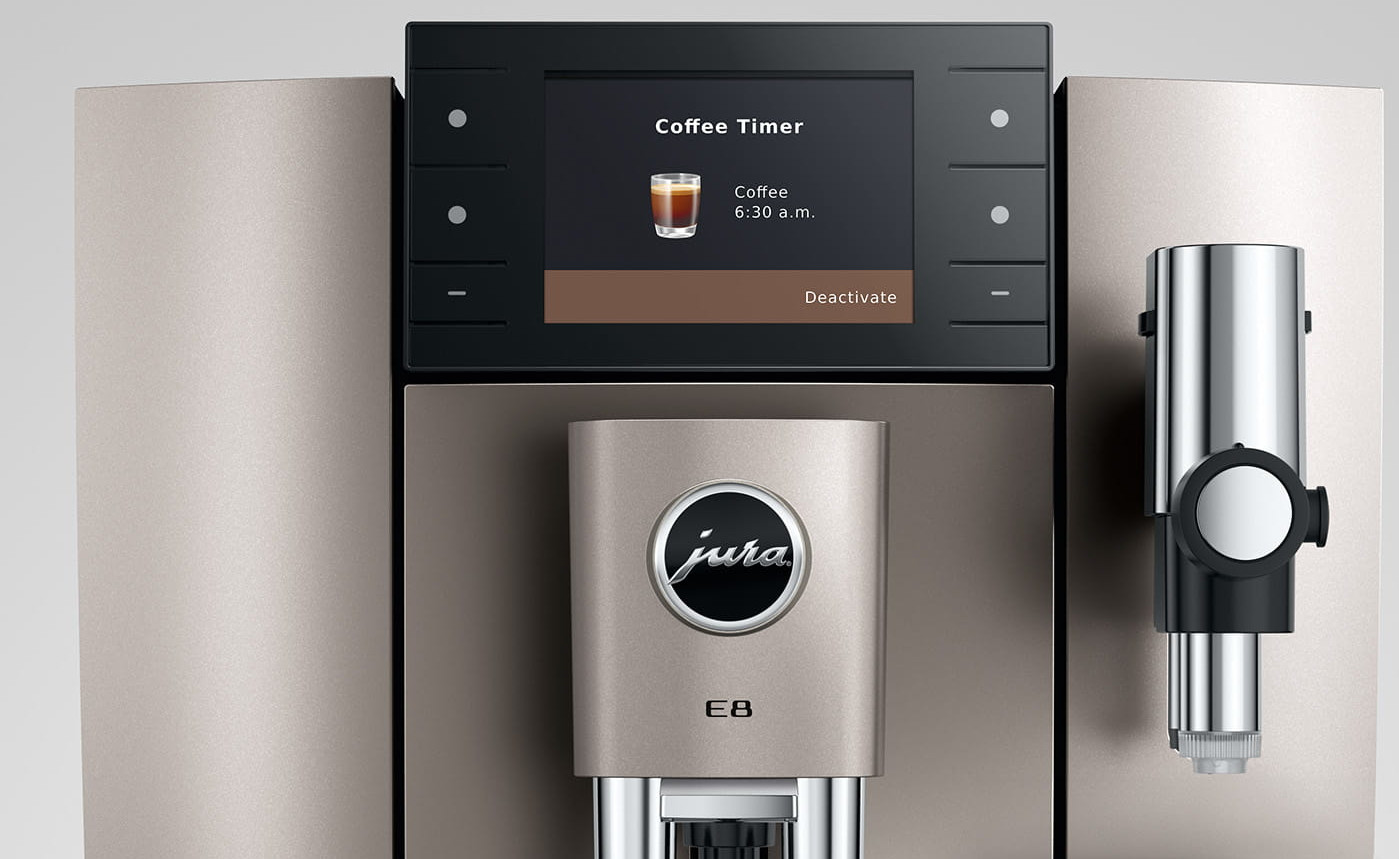 Ekspres do kawy z cyfrowym ekranem wyświetlającym 'Coffee Timer'. Widoczne logo 'Jura'. Maszyna ma srebrny i czarny design.