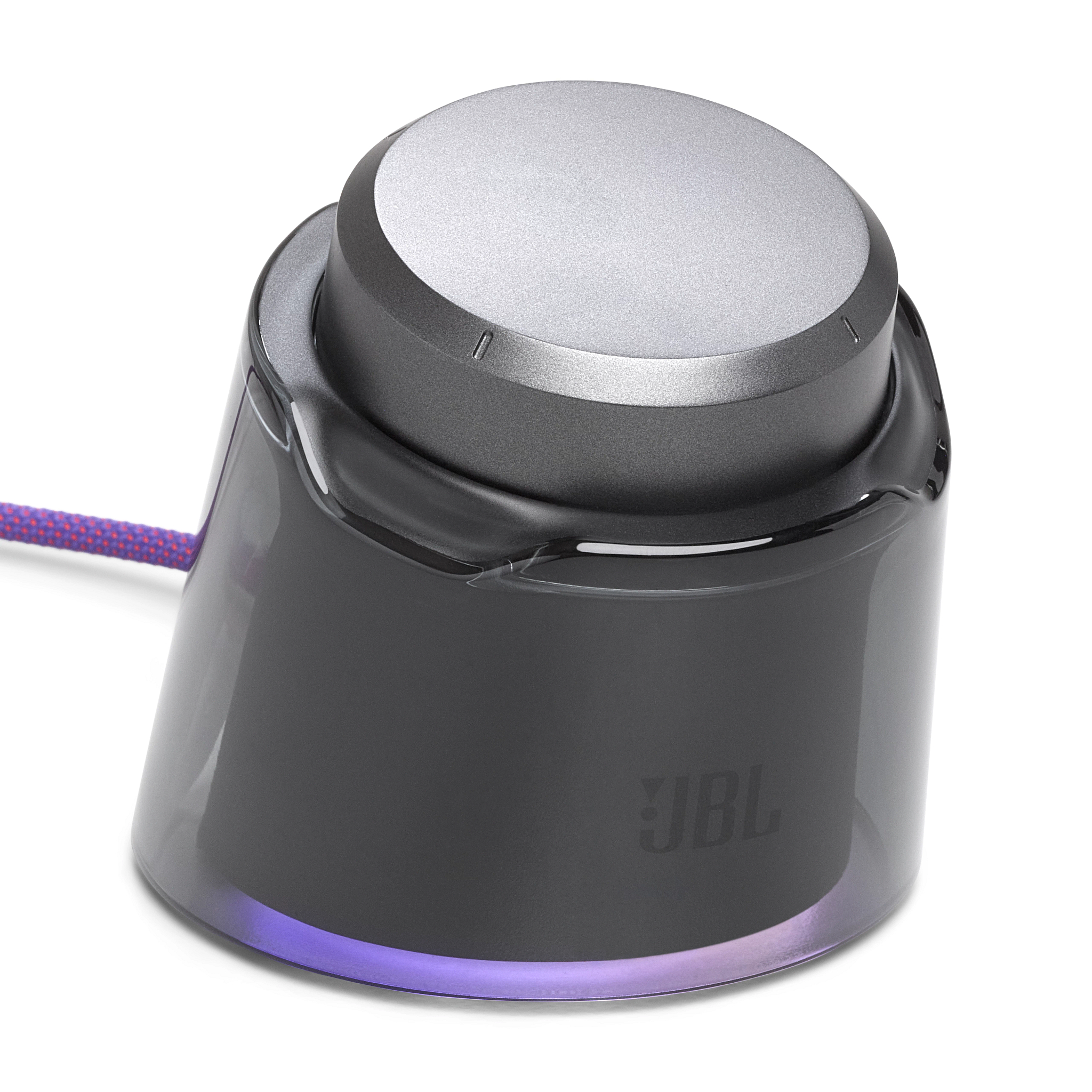 Ein JBL-Audioknopf. Er hat eine silberne Oberseite und einen transparenten dunkelgrauen Sockel mit lila Glühen am Boden.