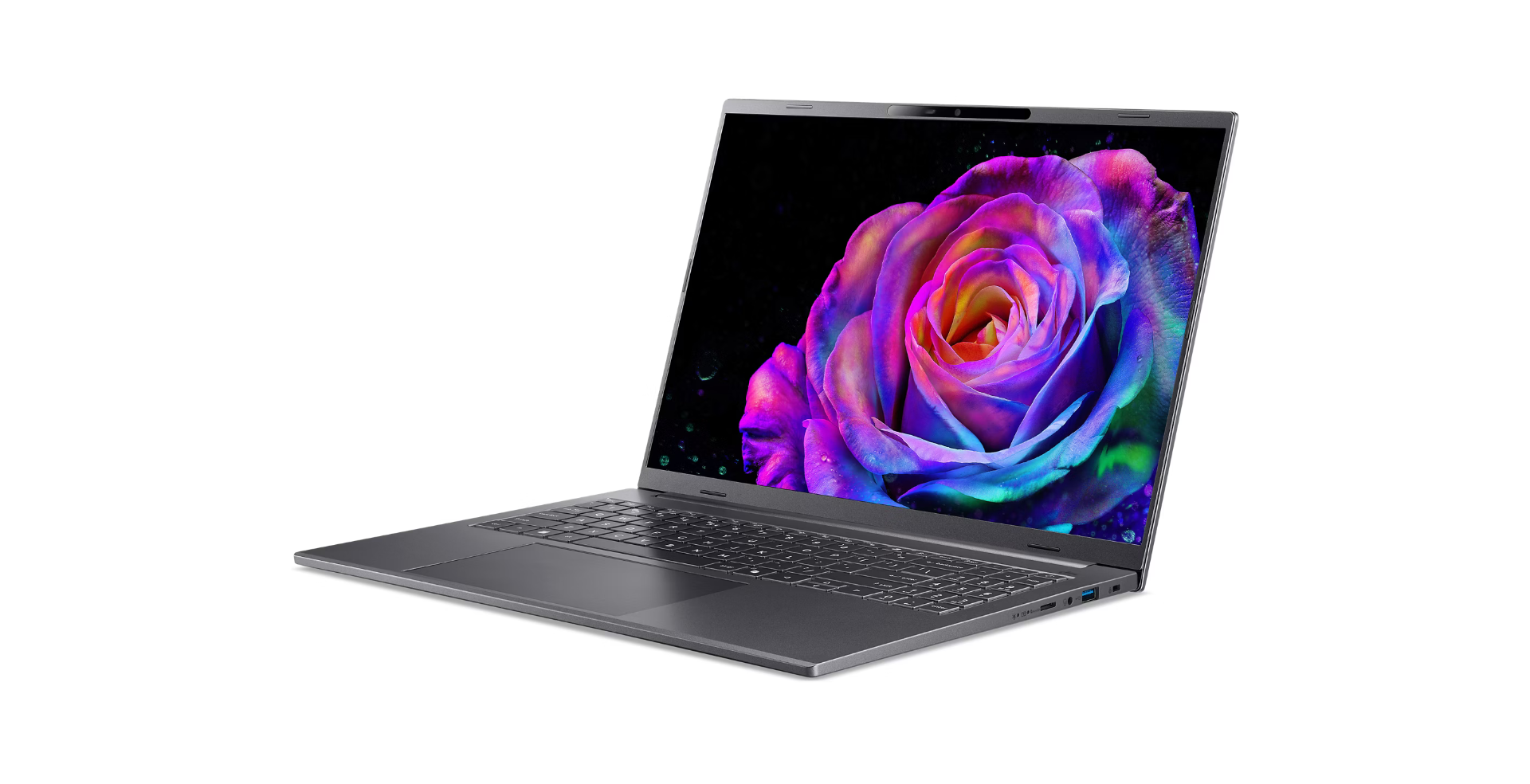 A gray laptop is open, displaying a colorful rose on the screen. The background is black, and the laptop sits on a white surface.