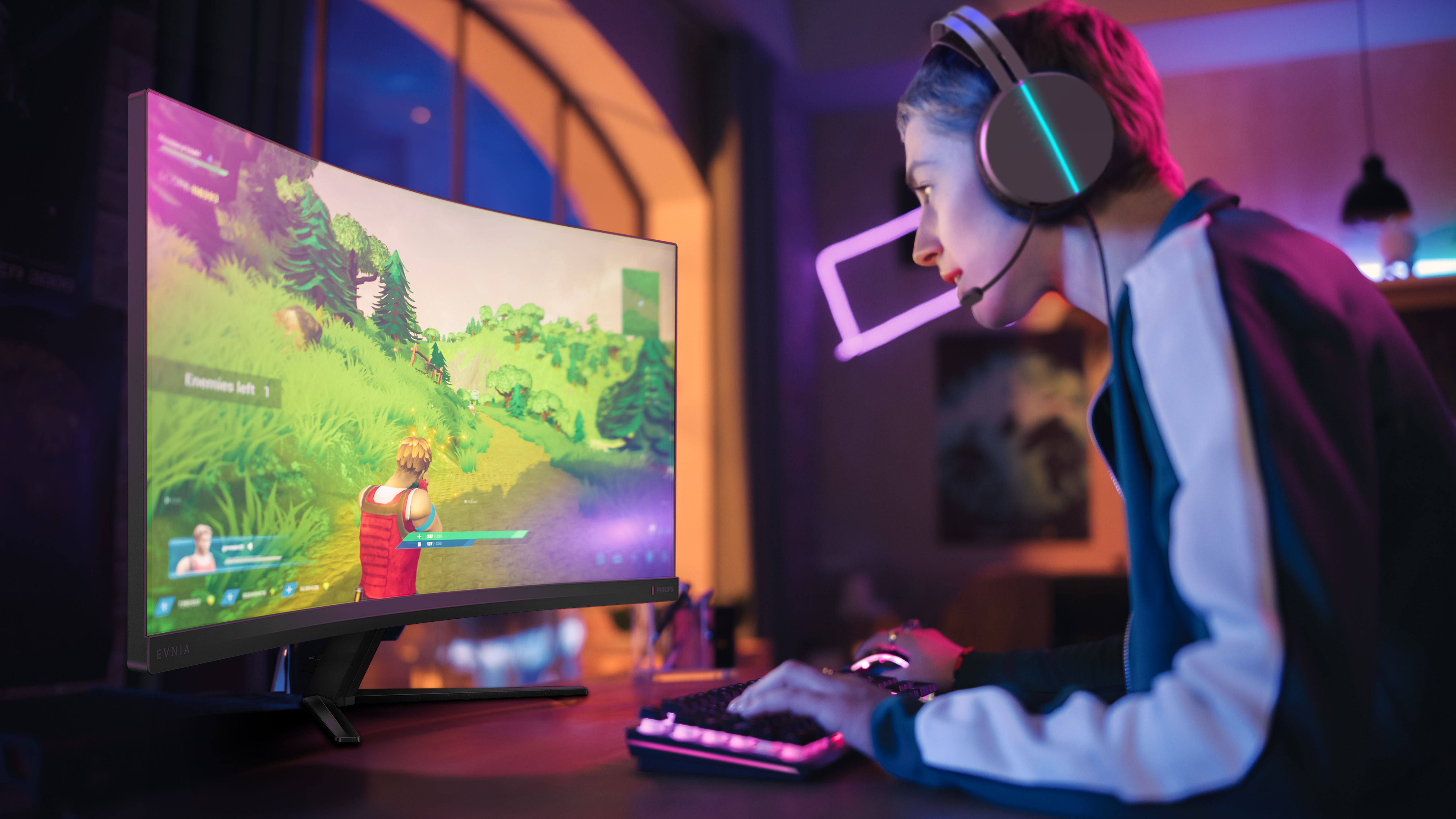 Eine Person mit Headset spielt. Ein gebogener Monitor zeigt ein Videospiel. Tastatur und Maus befinden sich auf dem Schreibtisch.