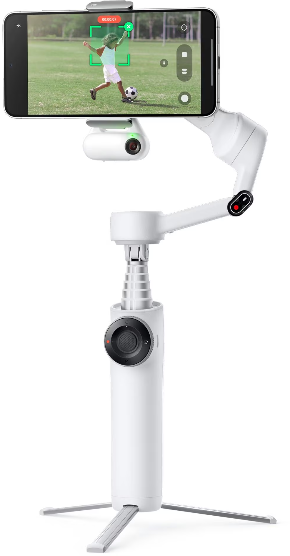 Ein weißer Gimbal mit einem Telefon zeigt ein Kind, das auf einem grünen Feld einen Fußball tritt. Der Gimbal hat eine Stativbasis.