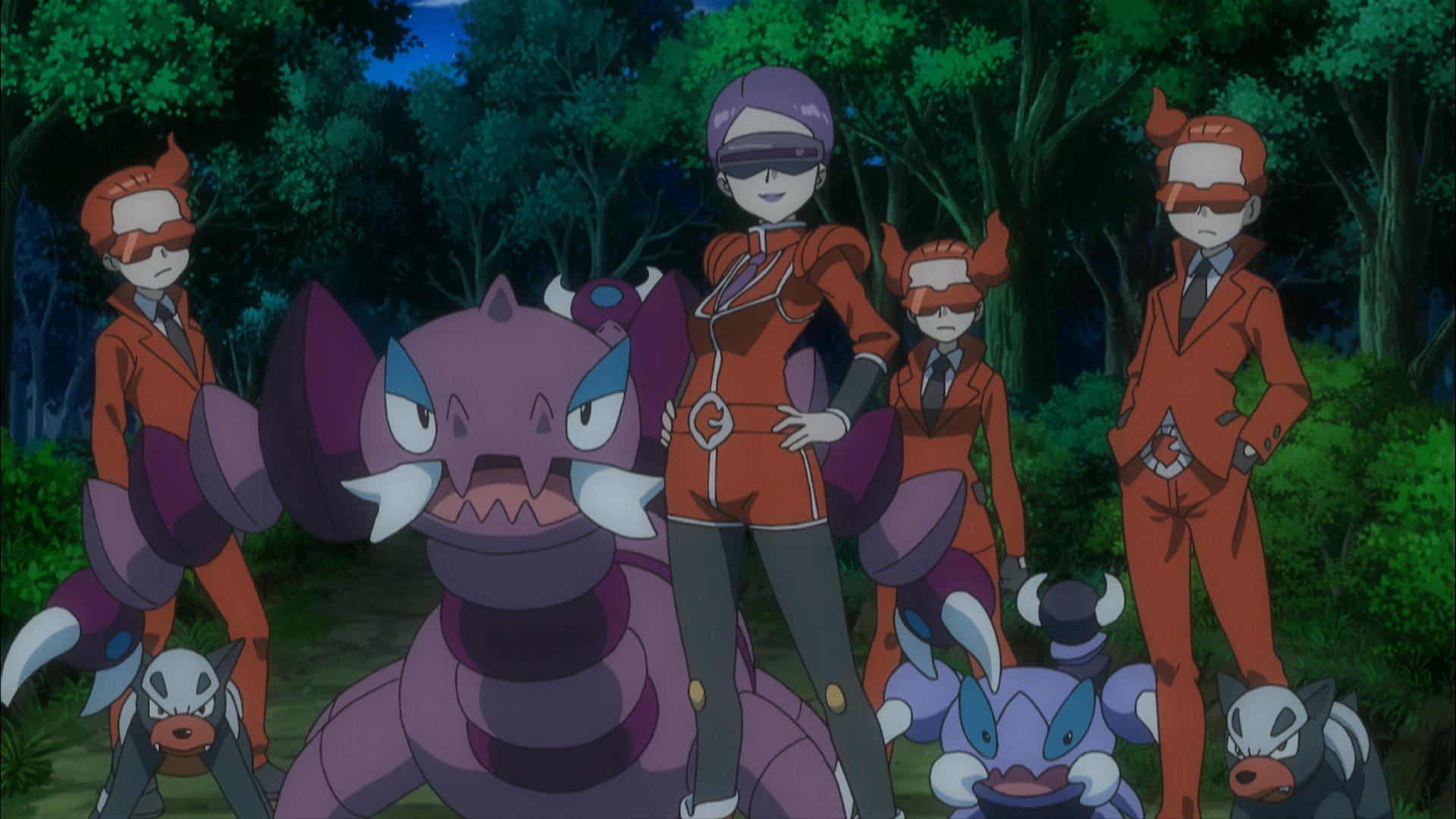 Eine Gruppe von Personen in orangefarbenen Anzügen mit Sonnenbrillen und Pokémon in einer Waldumgebung.