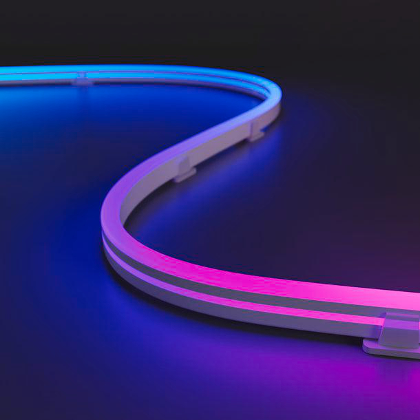 Ein gebogener LED-Lichtstreifen mit blauem und rosa Licht liegt auf einer dunklen Oberfläche. Der Lichtstreifen ist weiß mit Farbverlauf.