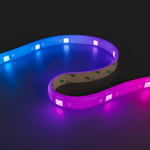 Ein flexibles LED-Band, das von Blau über Lila zu Rosa übergeht. Das Band hat Klebeband und befindet sich auf einer dunklen Oberfläche.
