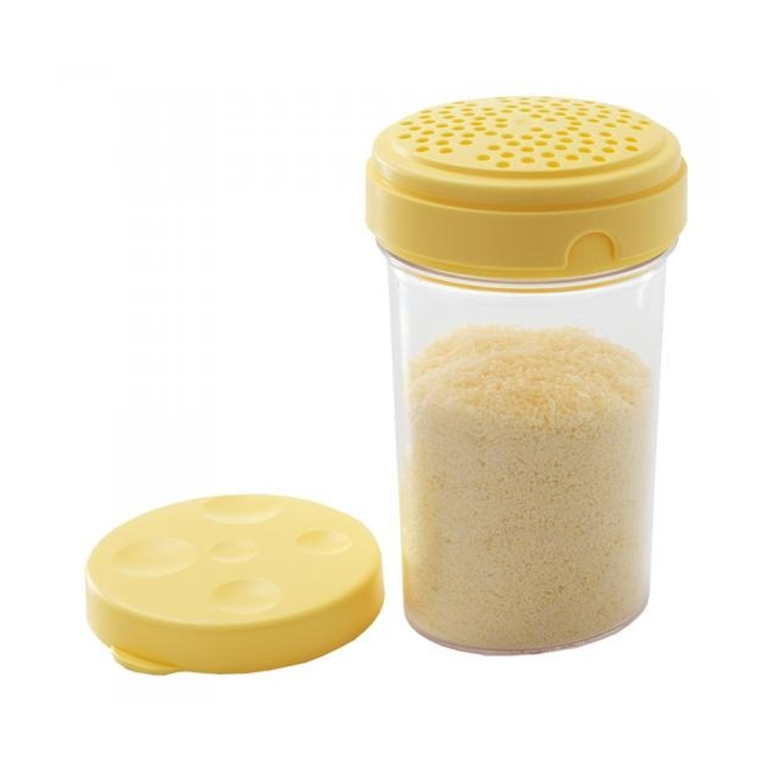 Uno shaker per formaggio giallo con un coperchio e un coperchio separato. Lo shaker è pieno di formaggio grattugiato. Lo sfondo è bianco.