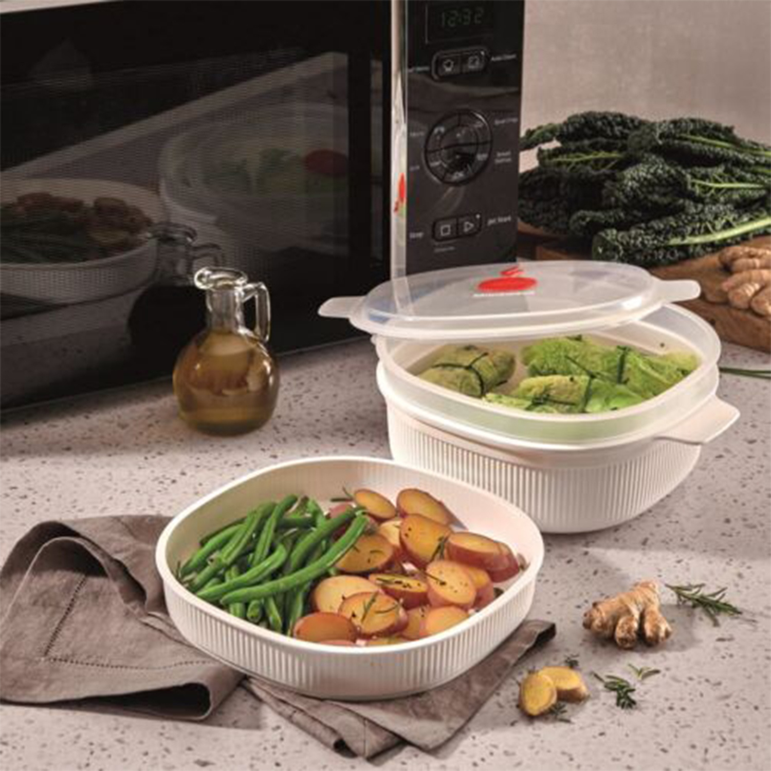 Una scena di cucina con verdure e utensili da cucina. Sono visibili un microonde, una vaporiera e una ciotola con fagiolini e patate.