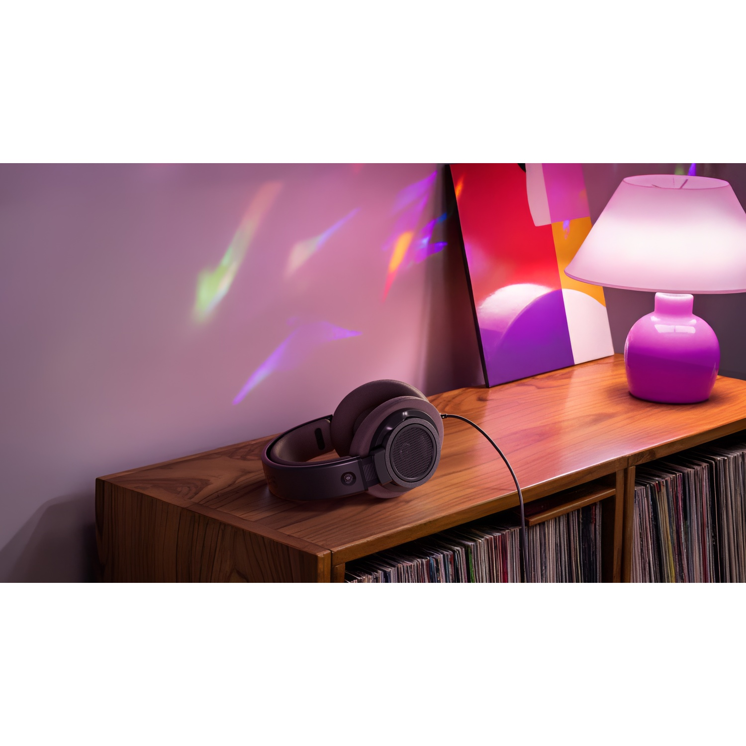 Cuffie su un mobile di legno, vicino a una lampada e opere d'arte. Lo sfondo mostra riflessi di luce e dischi in vinile.