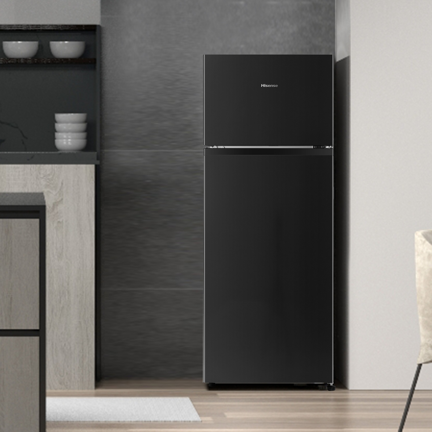 Un frigorifero nero in cucina. Il frigorifero Hisense è vicino a un muro grigio. Ciotole su uno scaffale.
