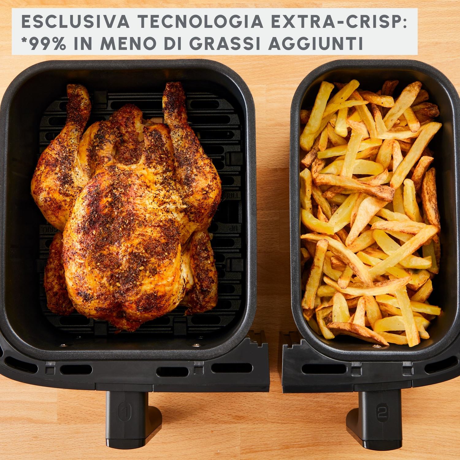 Una friggitrice ad aria con pollo arrosto a sinistra e patatine fritte a destra. Entrambi sono in vassoi neri. Superficie in legno.