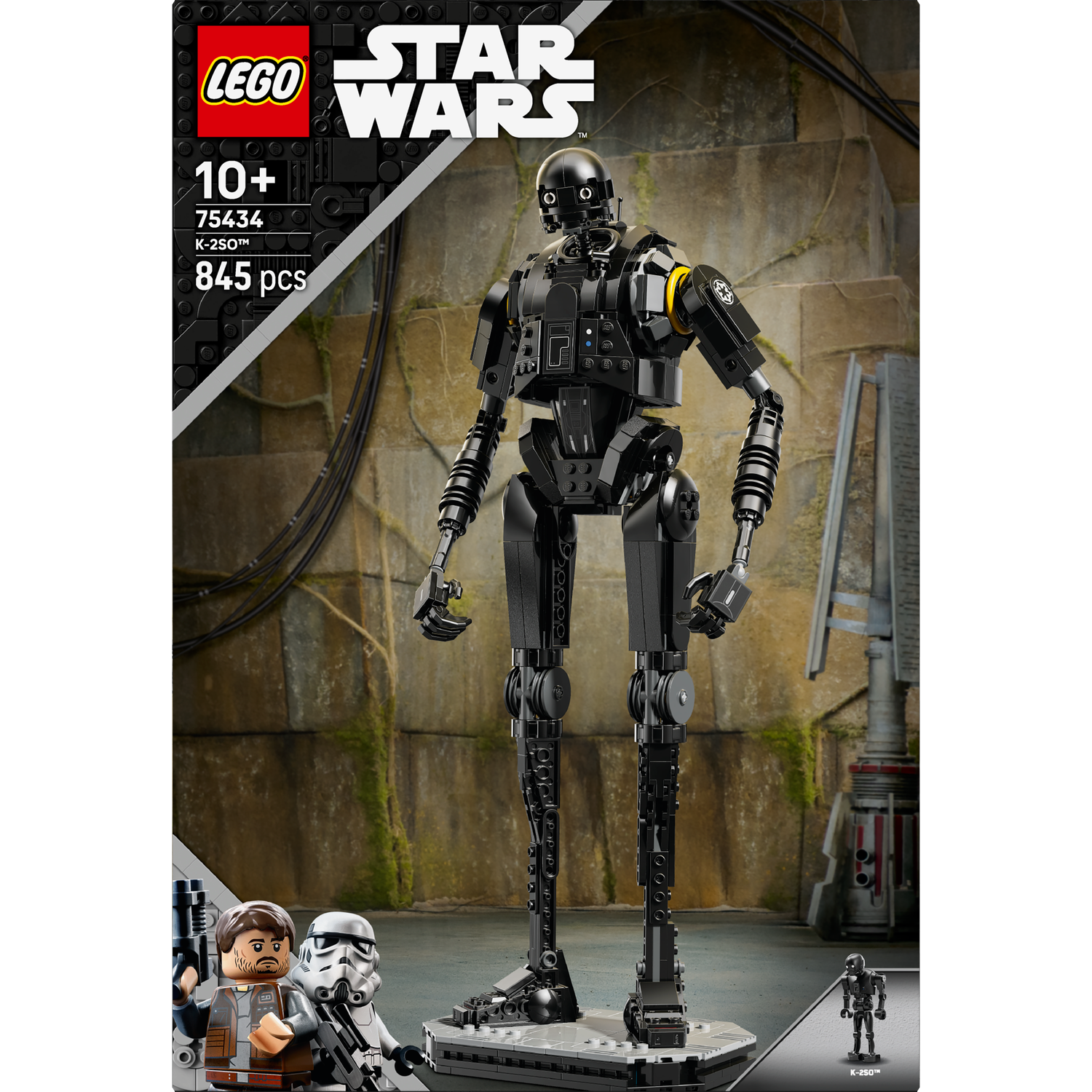 A Lego Star Wars set features a black K-2SO robot on a base. The background has a wall and the Lego logo is visible.
