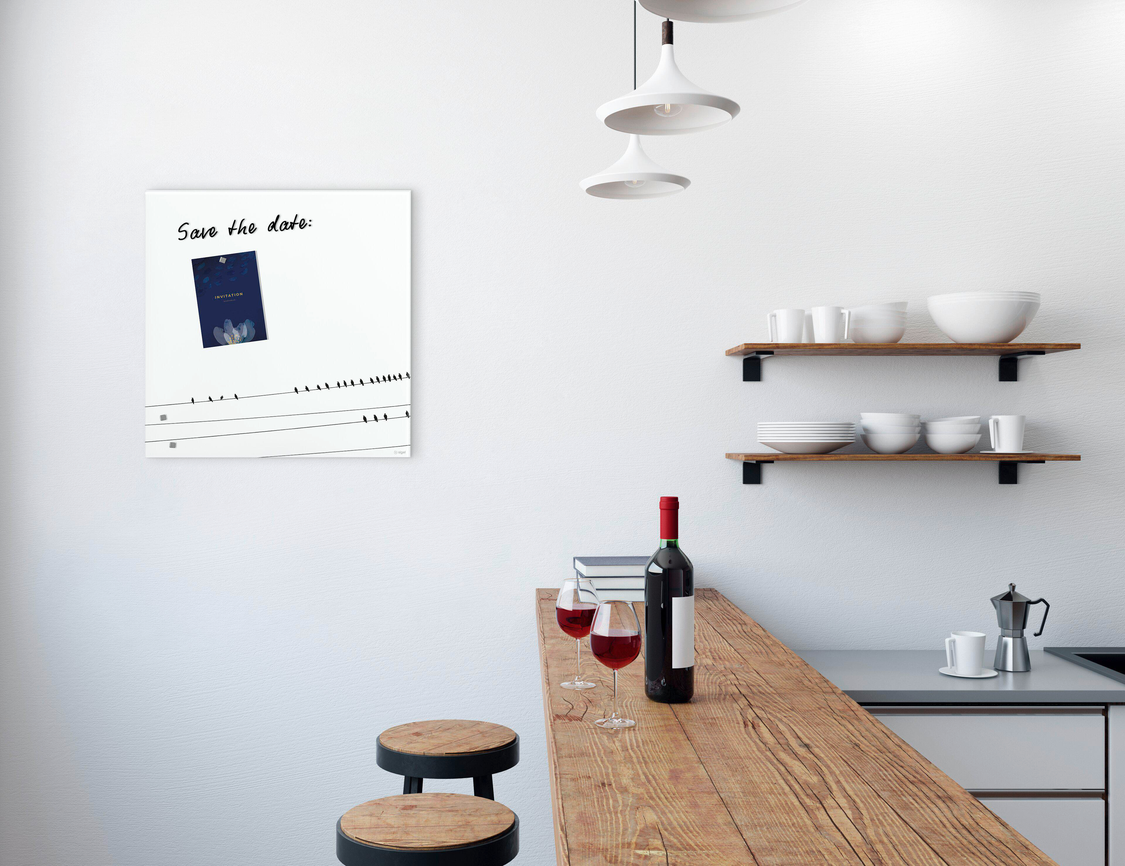 Eine Küchenszene mit Bar, Wein, Gläsern und einer Tafel mit einer Save-the-Date-Einladung.