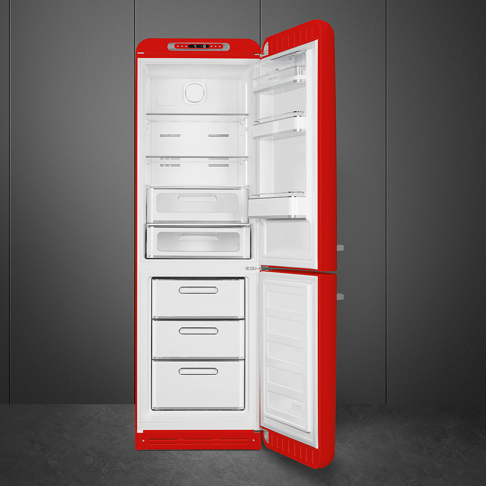 Ein roter Kühlschrank mit offener Tür, der weiße Innenräume zeigt. Es steht vor einer grauen Wand und einem grauen Boden.