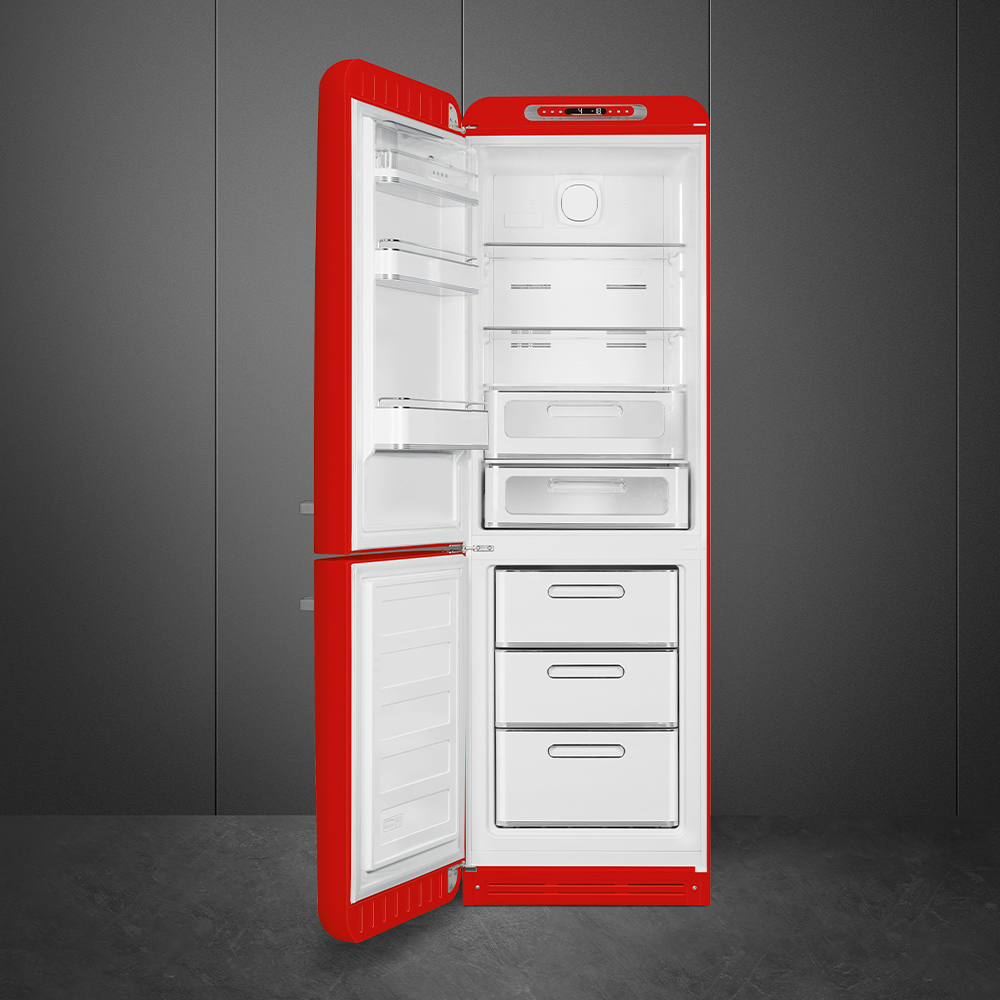 Ein roter Kühlschrank mit offener Tür, der weiße Innenräume und Regale zeigt. Der Hintergrund ist eine graue Wand und ein grauer Boden.