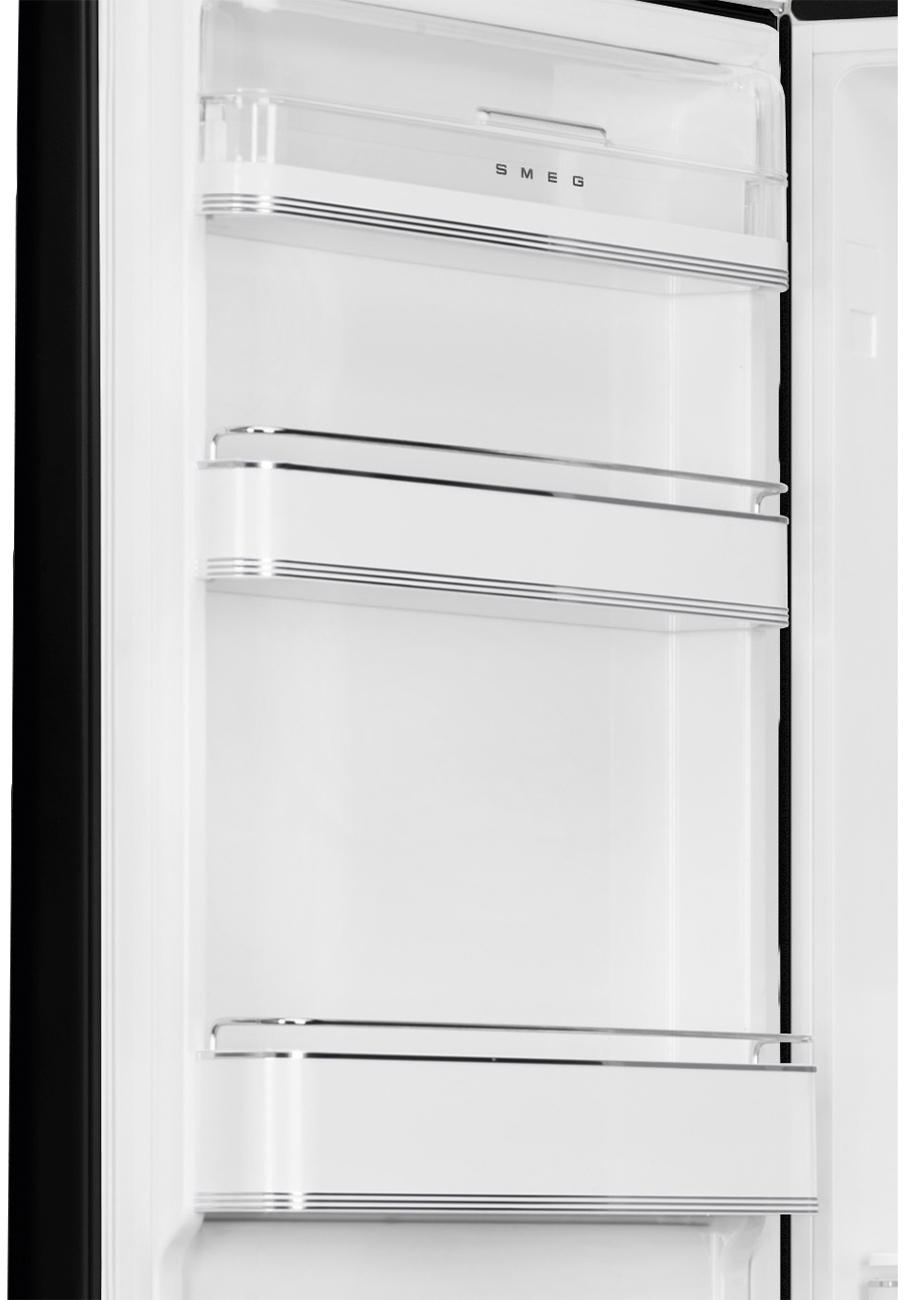 Offener weißer Kühlschrankinnenraum mit Regalen. SMEG-Logo oben sichtbar. Silberne Zierleisten auf den Regalen.