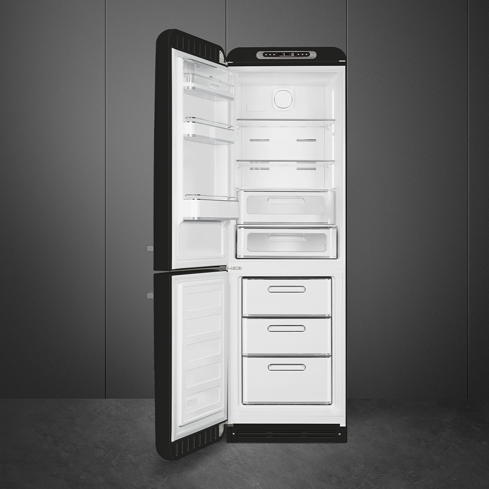 Ein schwarzer Kühlschrank mit offener Tür, der weiße Innenregale, Schubladen und Fächer zeigt. Der Hintergrund ist eine graue Wand.