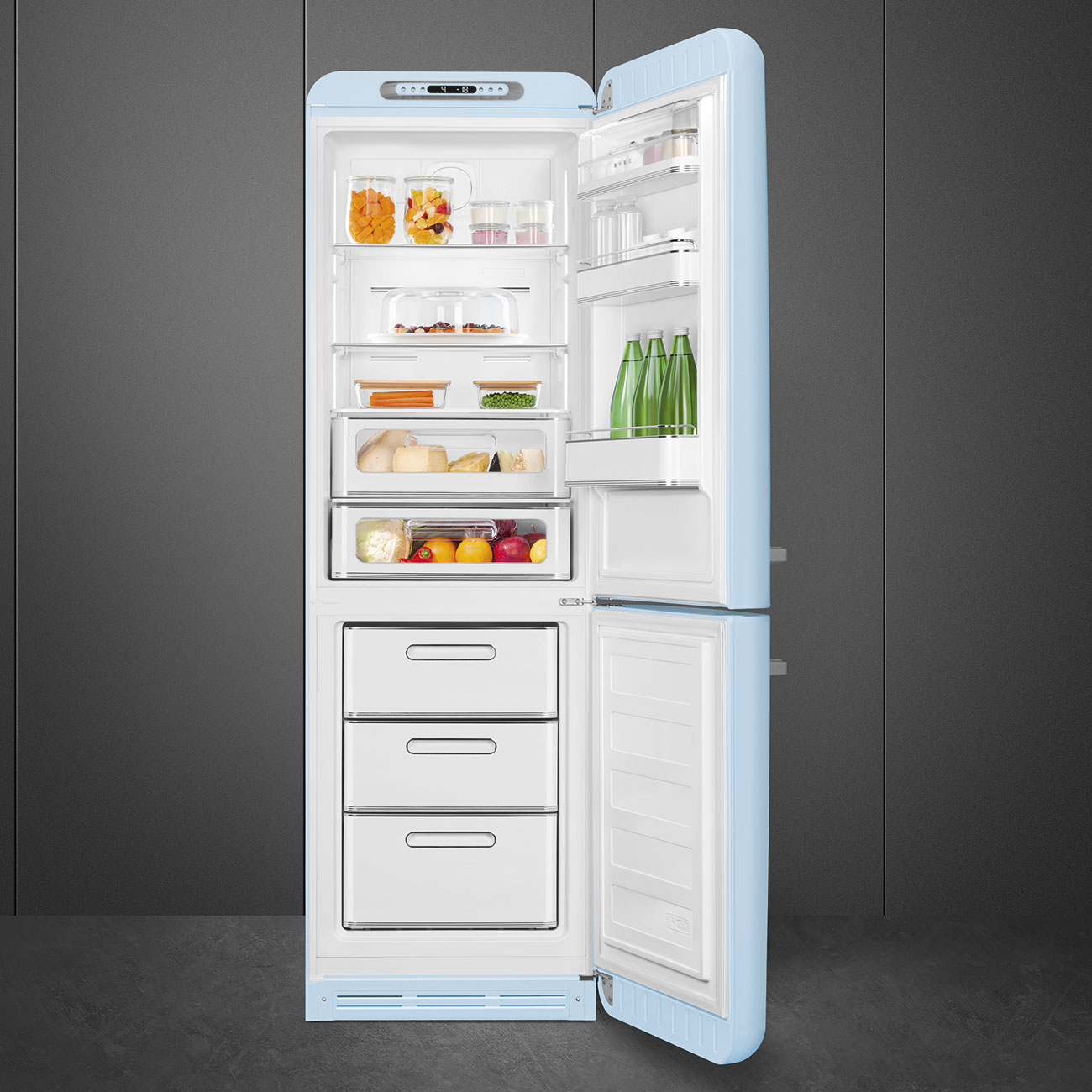 Geöffnete blaue Retro-Kühlschrank mit Lebensmitteln gefüllt. Gläser, Käse, Obst und Gemüse sind darin. Gefrierschubladen sind sichtbar.