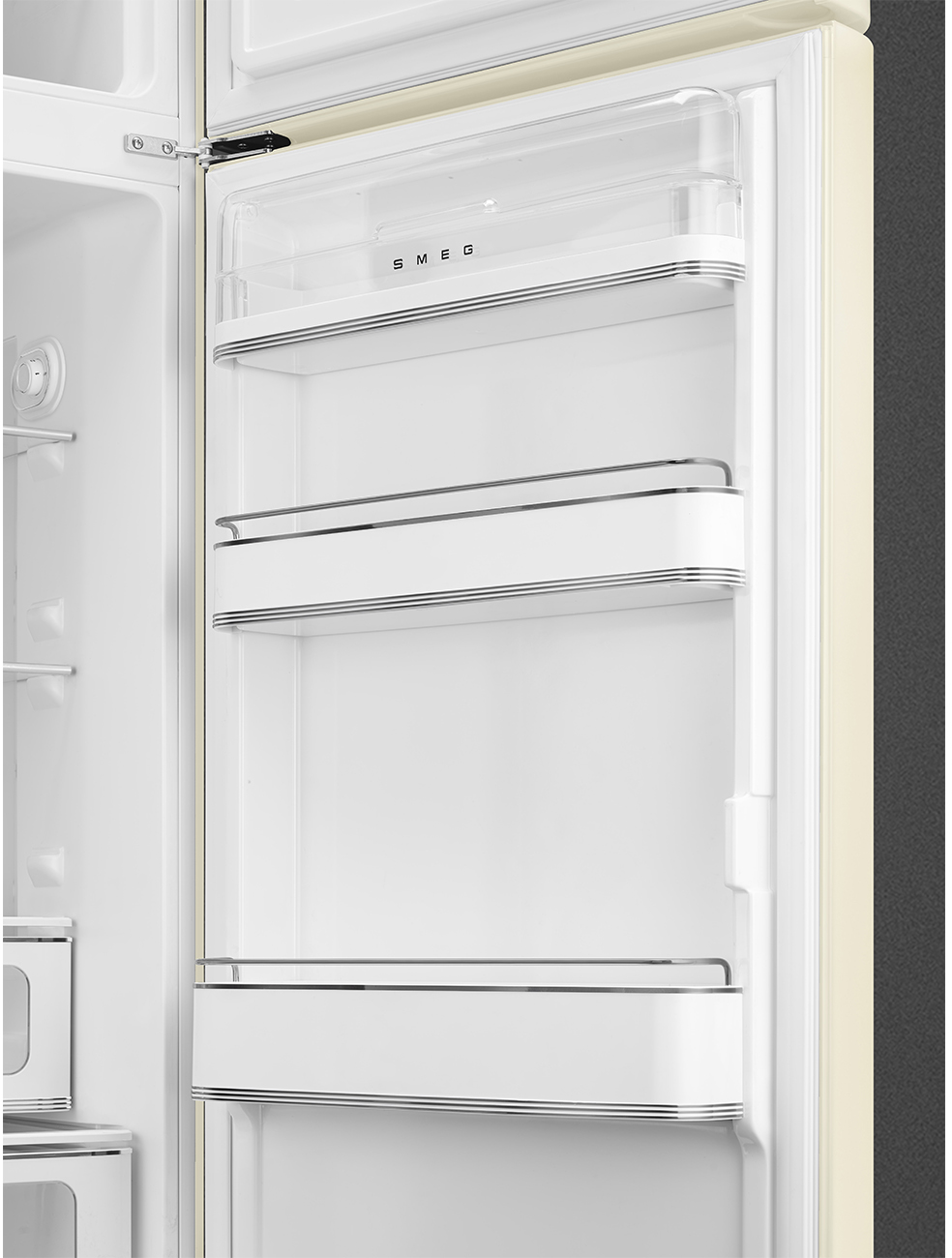 Offener Kühlschrankinnenraum. Weiße Regale und Fächer mit Chromgriffen sind sichtbar. Der Markenname SMEG ist oben.