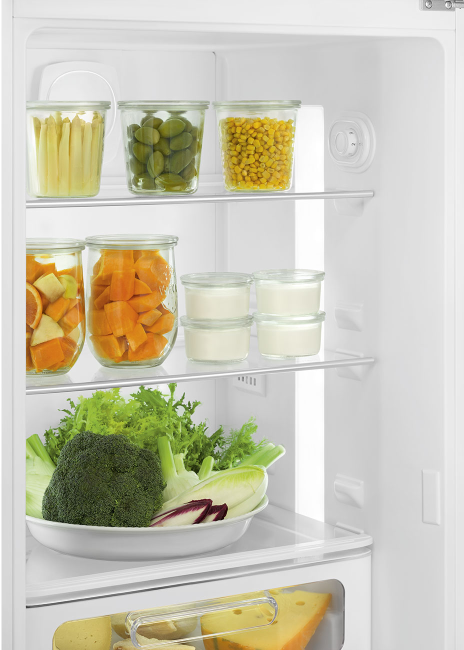 In einem Kühlschrank: Gläser mit Gemüse, Joghurt und eine Schüssel mit Grünzeug. Käse befindet sich im untersten Fach.