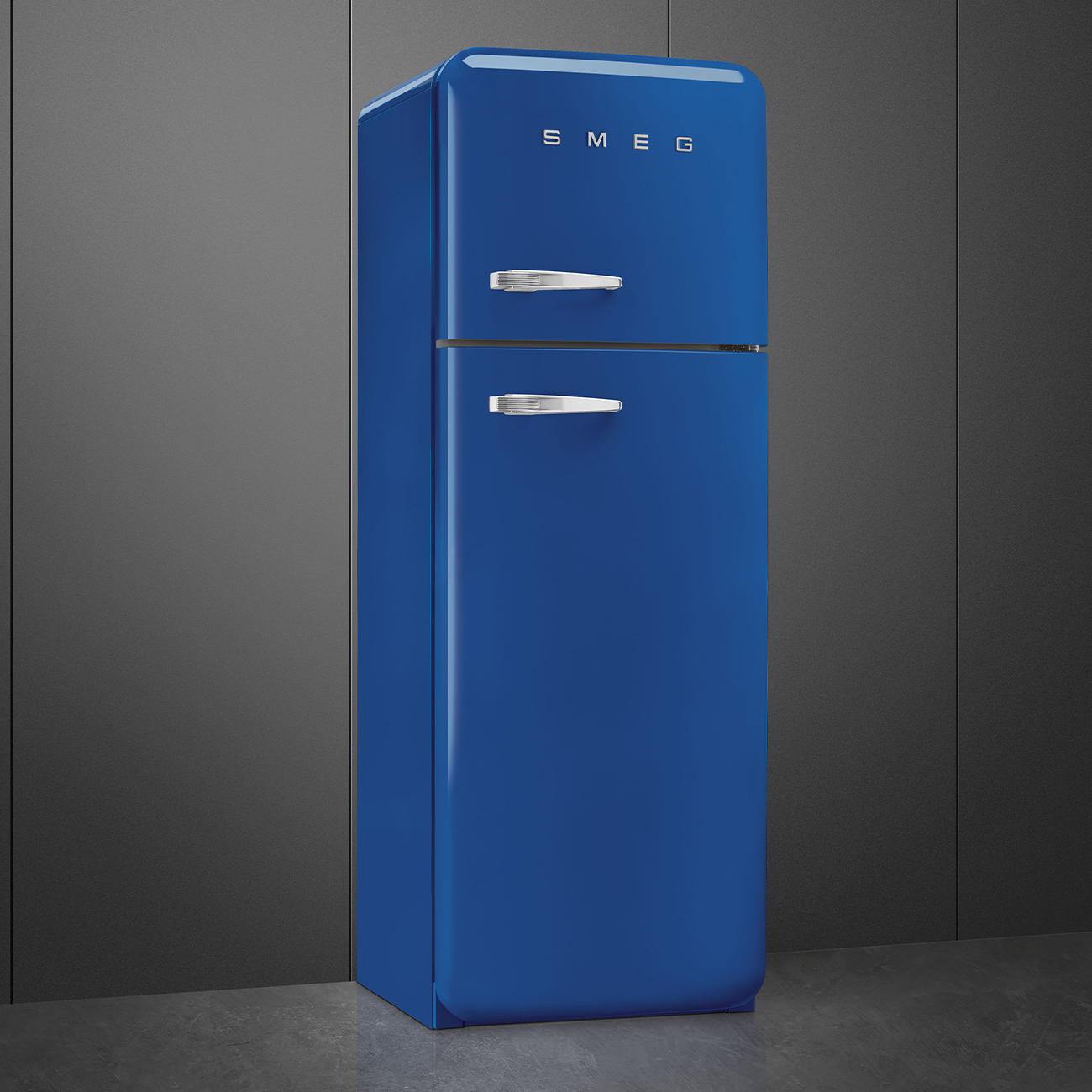 Ein blauer SMEG-Kühlschrank vor einem dunkelgrauen Hintergrund. Der Kühlschrank hat Chromgriffe und das SMEG-Logo oben.