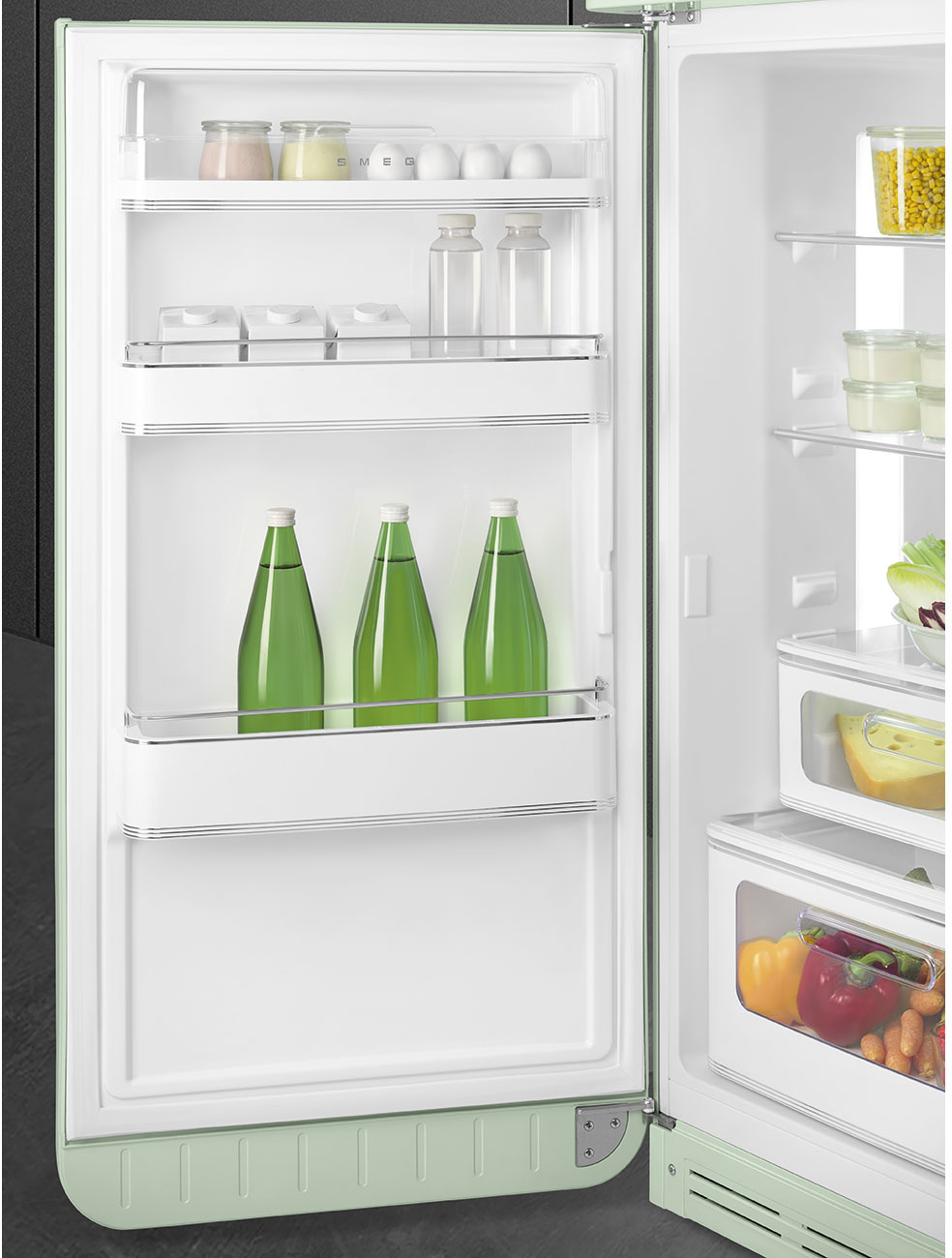 Offener, minzgrüner Kühlschrank mit Lebensmitteln gefüllt: Wasserflaschen, Eier, Gläser, Kartons, Gemüse und Käse. Es ist gut organisiert.