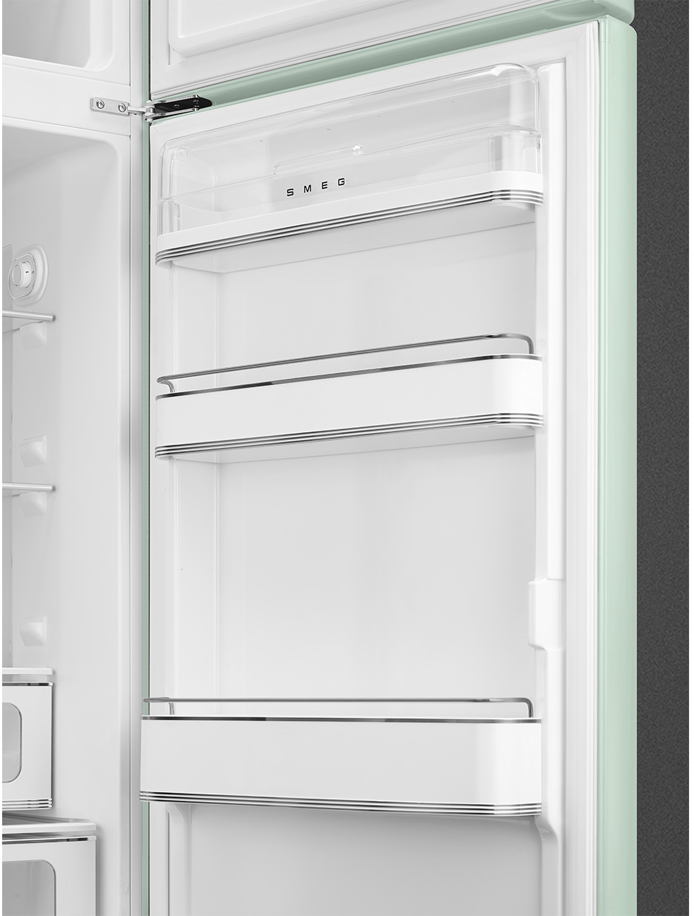 Geöffnete mintfarbene SMEG-Kühlschrank. Leerer weißer Innenraum mit Regalen und silbernen Zierleisten. Klare Plastikbox oben. Schwarzer Hintergrund.