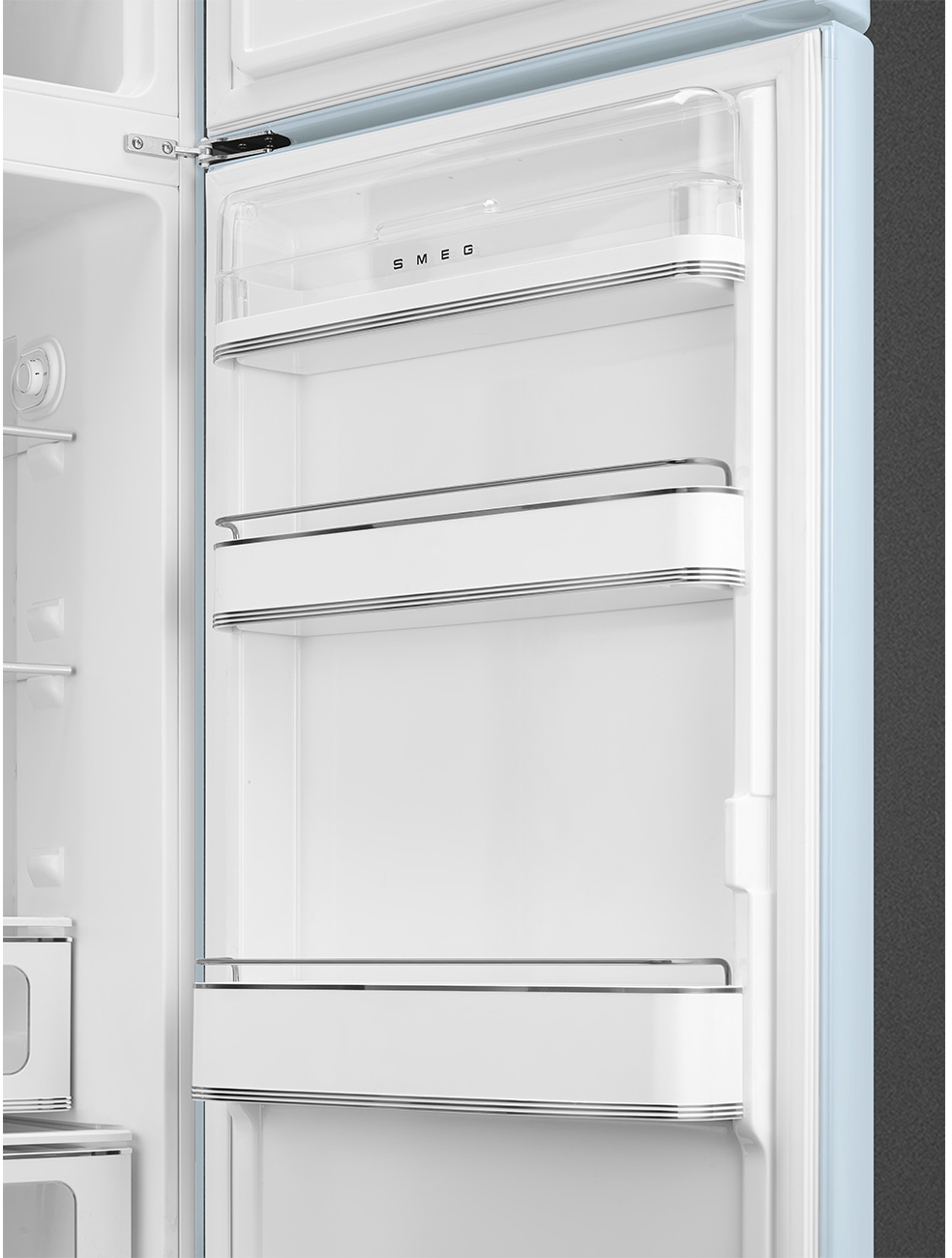 Offener, leerer, hellblauer Kühlschrankinnenraum. Weiße Regale mit Metallgeländern. Smeg-Logo sichtbar. Klare Kunststoff-Regalabdeckung.