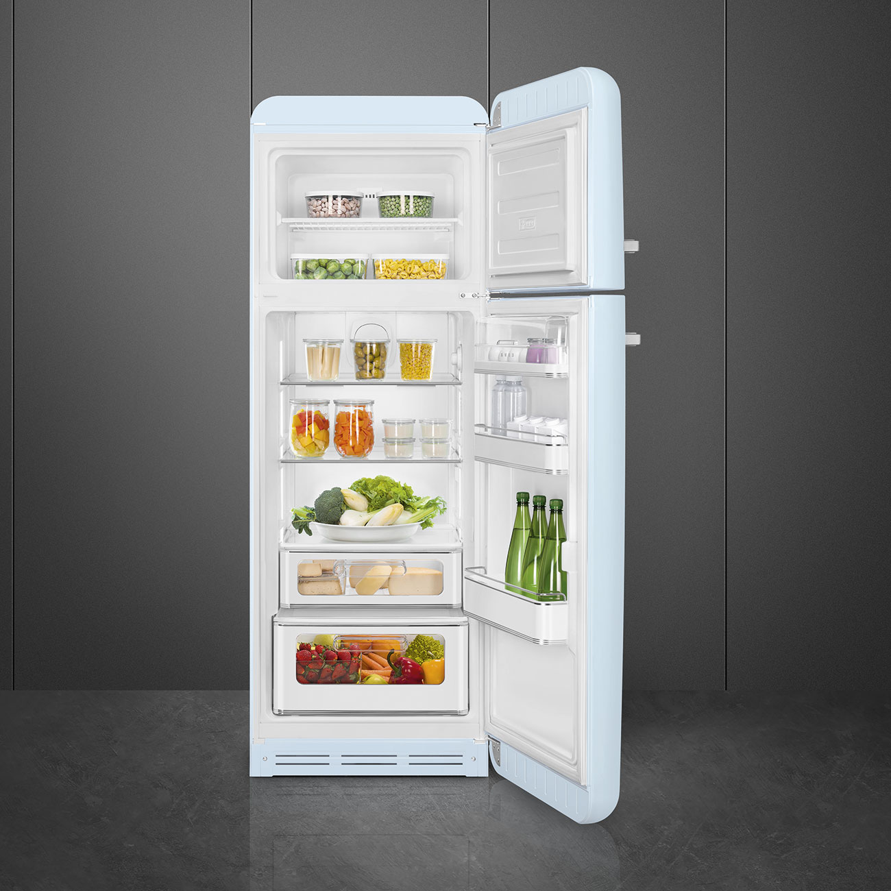 Offener hellblauer Kühlschrank mit Lebensmitteln. Enthält Gemüse, Obst, Gläser und Flaschen. Grauer Hintergrund und Boden sind sichtbar.