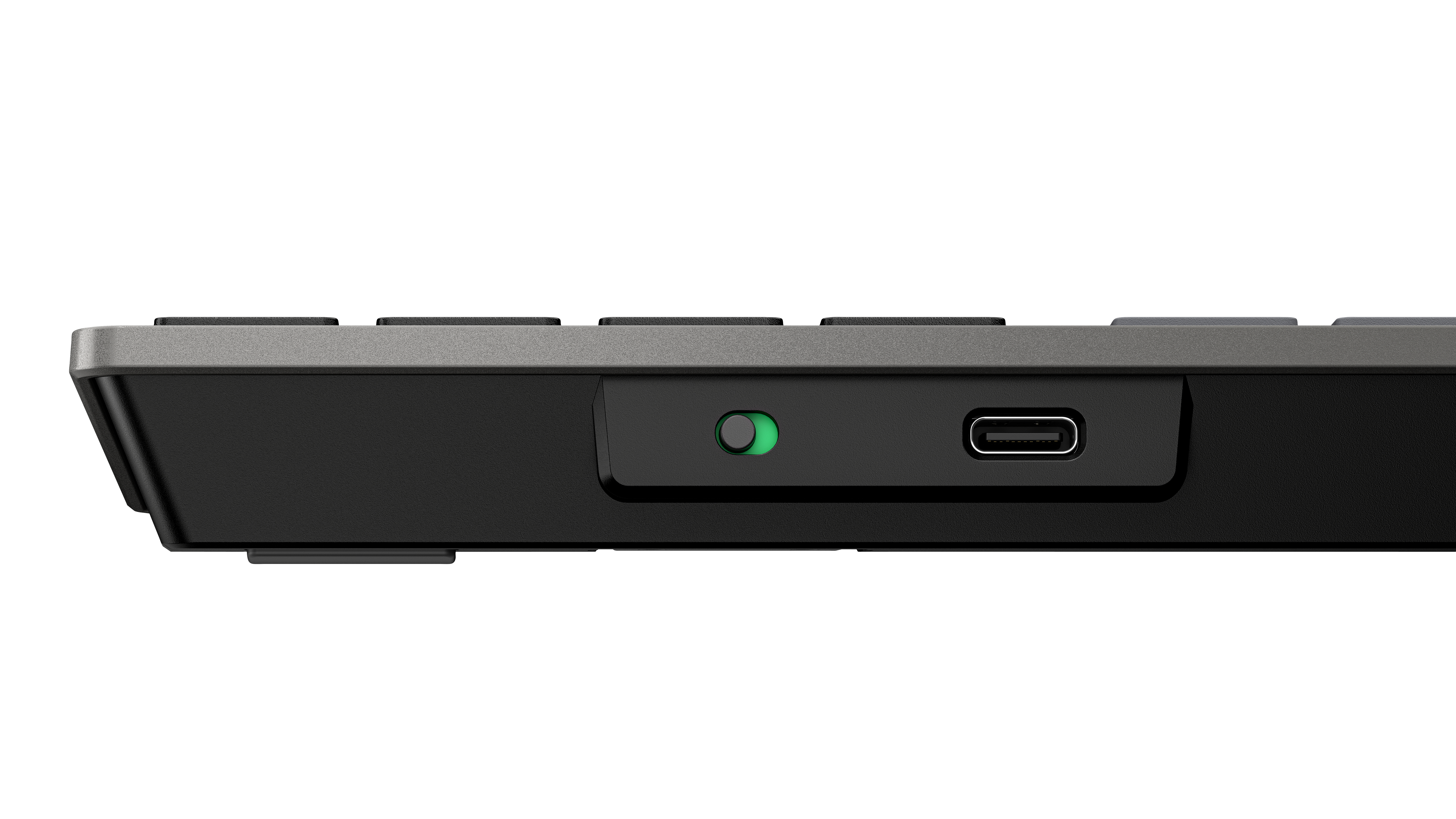 Seitenansicht einer schwarzen Tastatur. Sie hat einen grünen Netzschalter und einen USB-C-Anschluss. Der Hintergrund ist weiß.