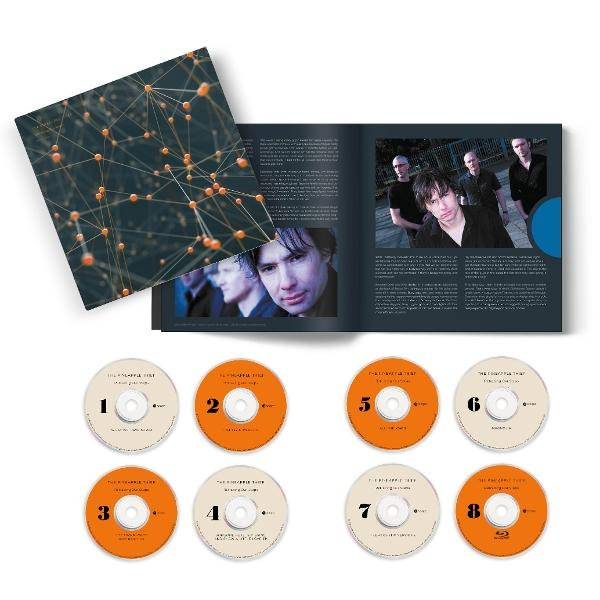 Album mit Cover und Bandfoto, plus acht CDs, nummeriert 1-8. Das Cover zeigt ein Netzwerk aus orangen Kugeln auf dunklem Hintergrund.