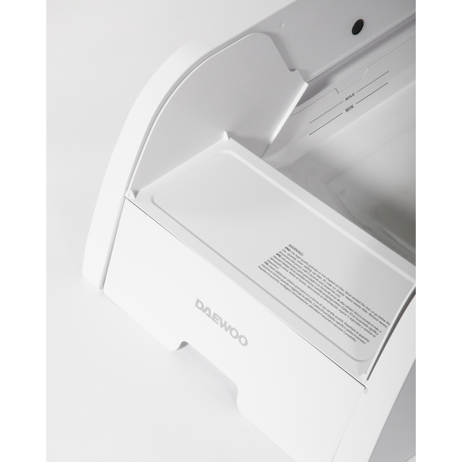 Interno bianco dell'apparecchio Daewoo con indicatori MAX/MIN. Testo sulla lettiera per gatti e avvertenze.