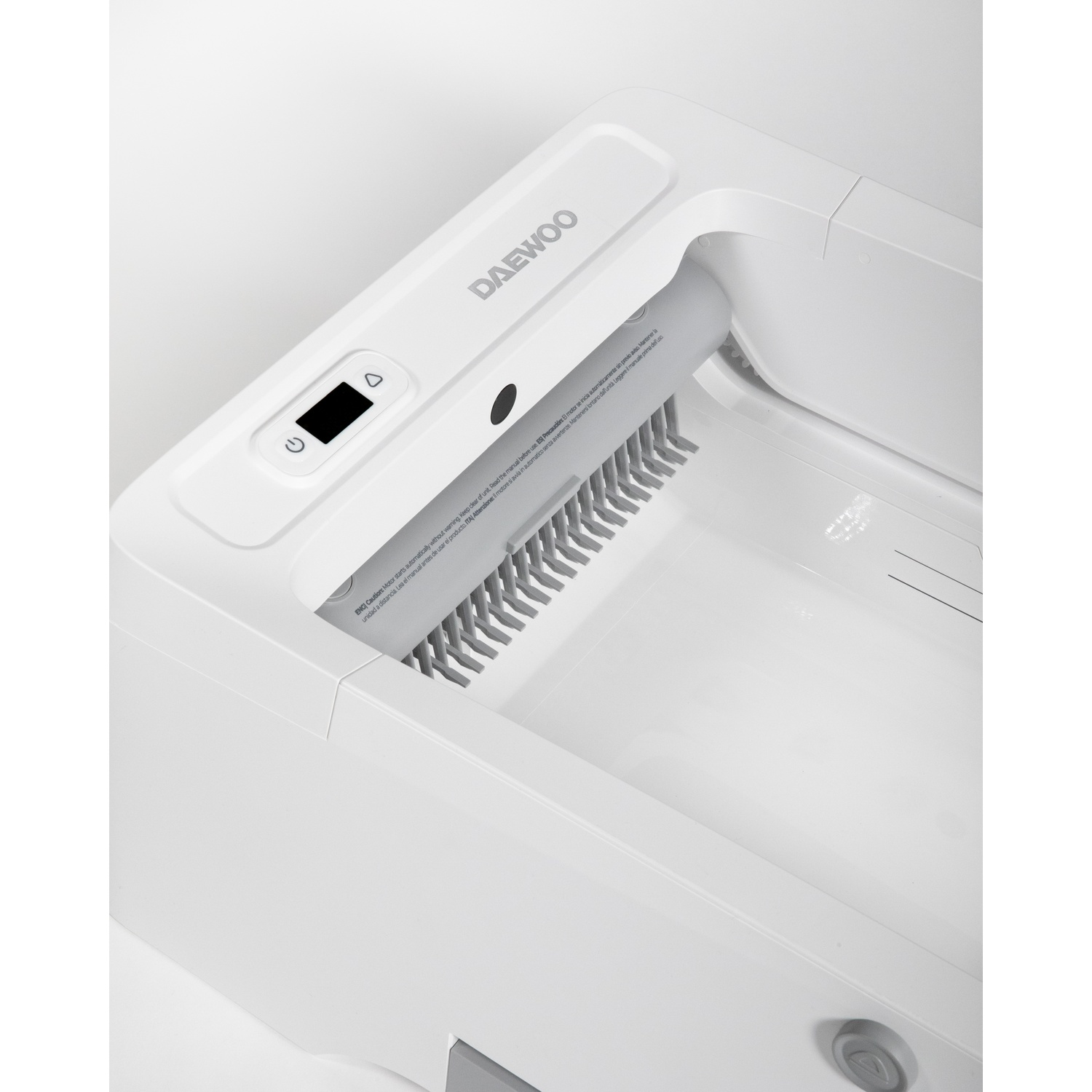 Un prodotto Daewoo bianco. Ha un display digitale e un vano con un rullo grigio dentato. Il prodotto presenta avvertenze stampate.