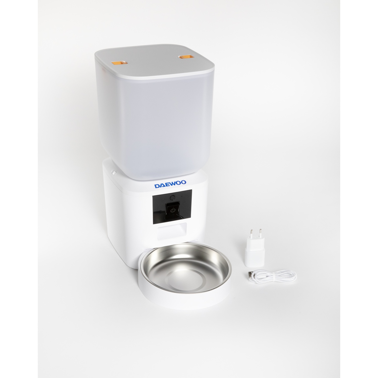 Erogatore di cibo per animali Daewoo bianco con ciotola in acciaio inox. Caricabatterie e cavo accanto. Coperchio grigio e contenitore trasparente.