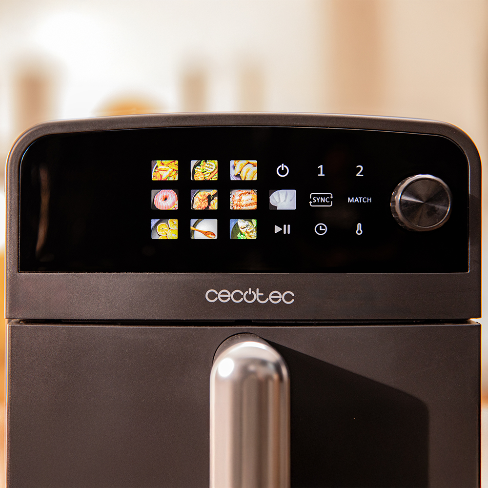 Primer plano de una freidora de aire Cecotec negra con pantalla digital que muestra iconos de comida, botones y una perilla. Se ve un mango metálico.