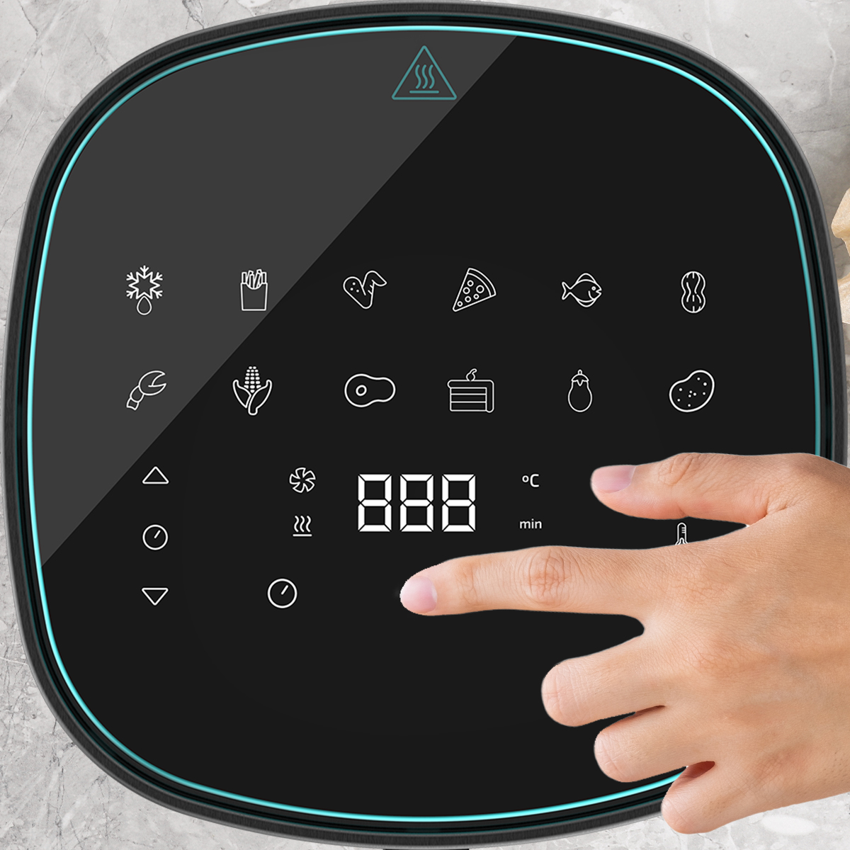 Una mano toca un panel de control negro de una freidora de aire que muestra iconos de cocción y temperatura. La pantalla muestra 888 grados.