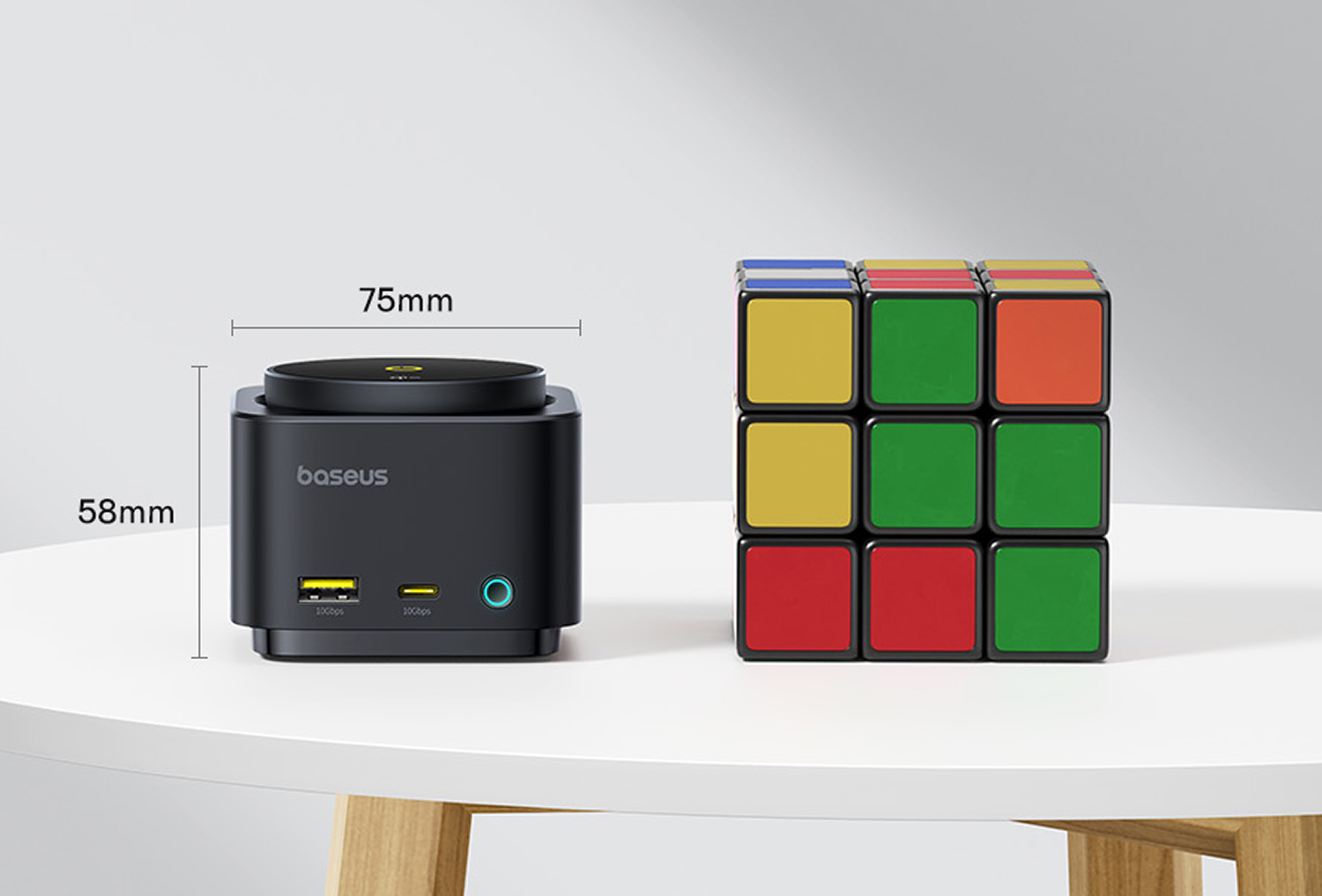 Un concentrador Baseus negro junto a un cubo de Rubik sobre una mesa blanca. Se muestran las dimensiones 75 mm x 58 mm.