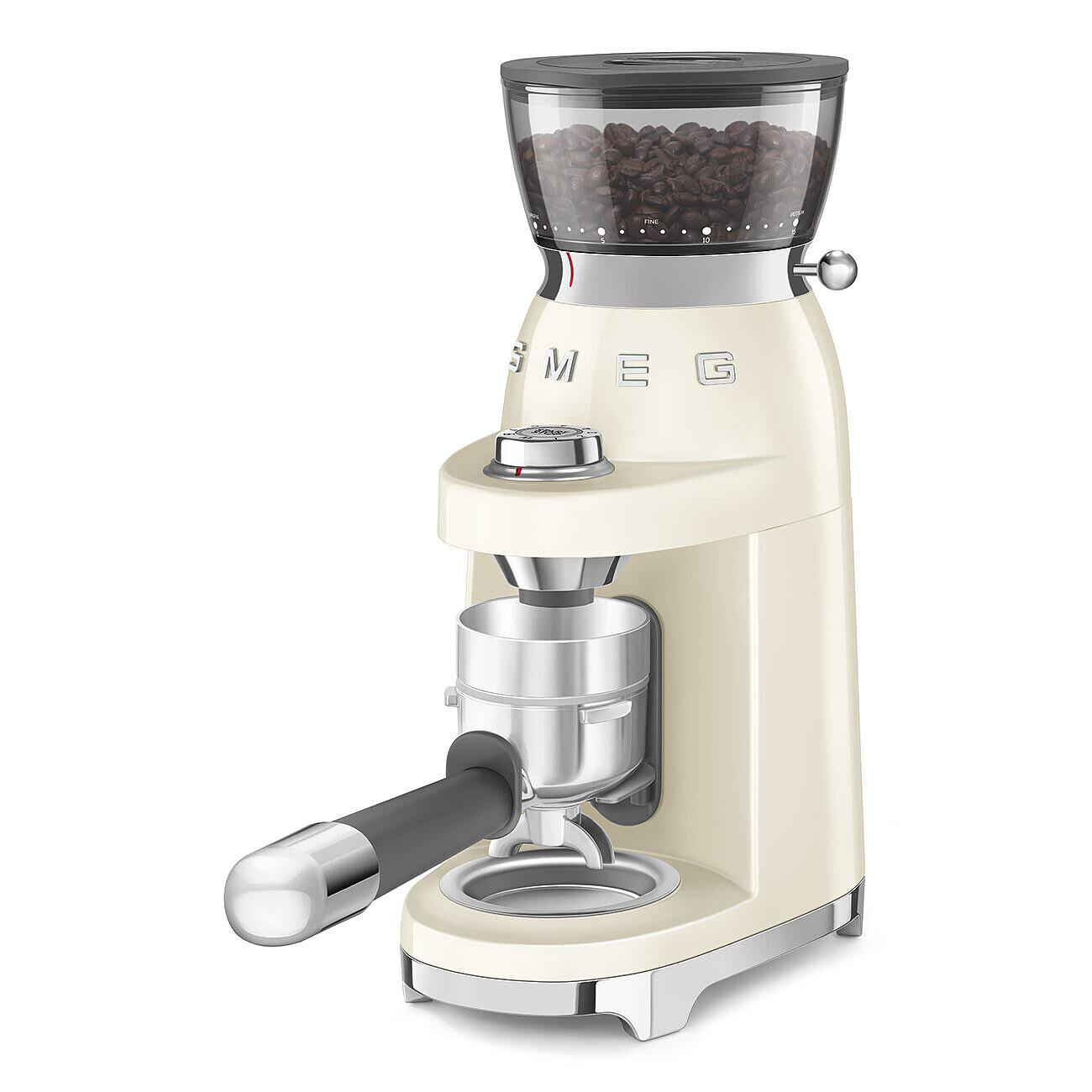 Cremefarbene SMEG Kaffeemühle. Sie hat einen Bohnenbeh älter, Mahleinstellungen und einen Siebträgerhalter. Der Hintergrund ist weiß.