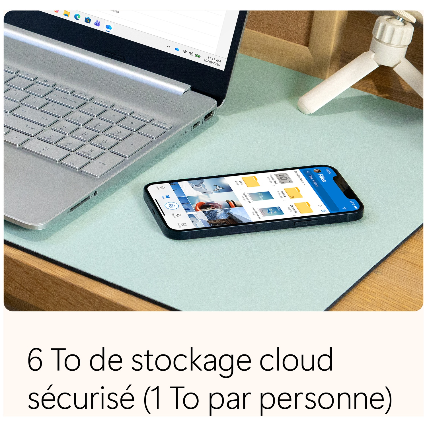 Ordinateur portable, téléphone avec application de fichiers et petit trépied sur un tapis de bureau bleu clair. Texte en bas dit stockage cloud.