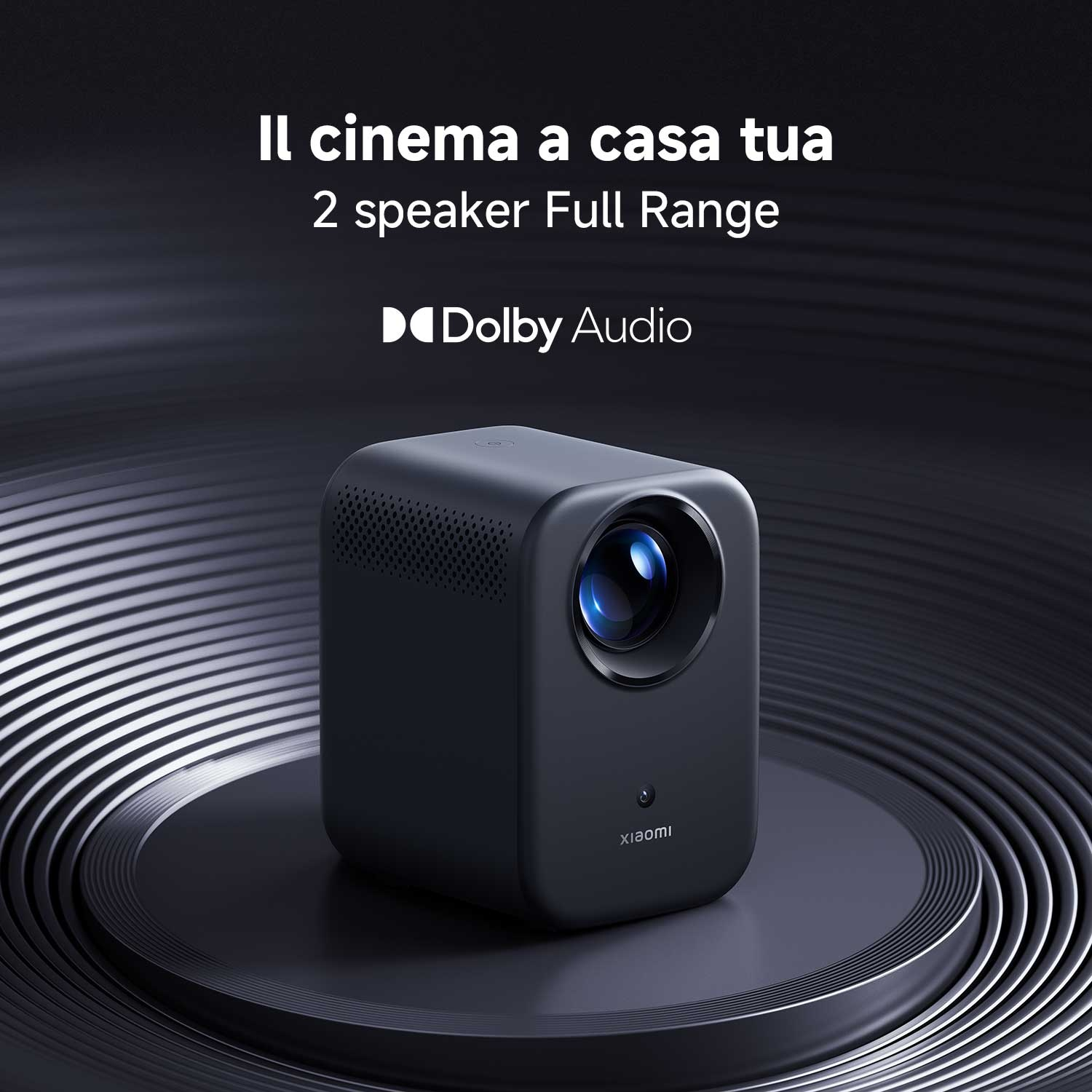 Un proiettore Xiaomi nero su una piattaforma scura. Il testo recita: Il cinema a casa tua, 2 speaker Full Range, Dolby Audio.