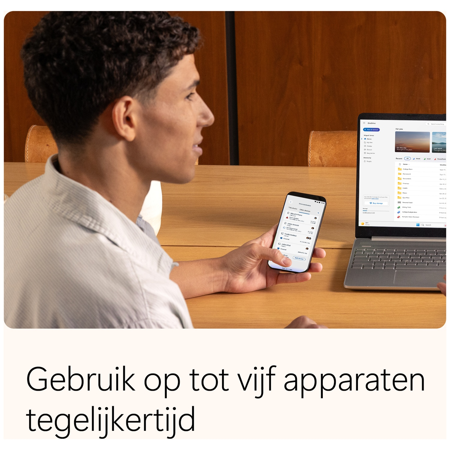 A man uses a phone and laptop. Phone shows app, laptop shows files. Wooden background. Text in Dutch: Use on up to five devices simultaneously.