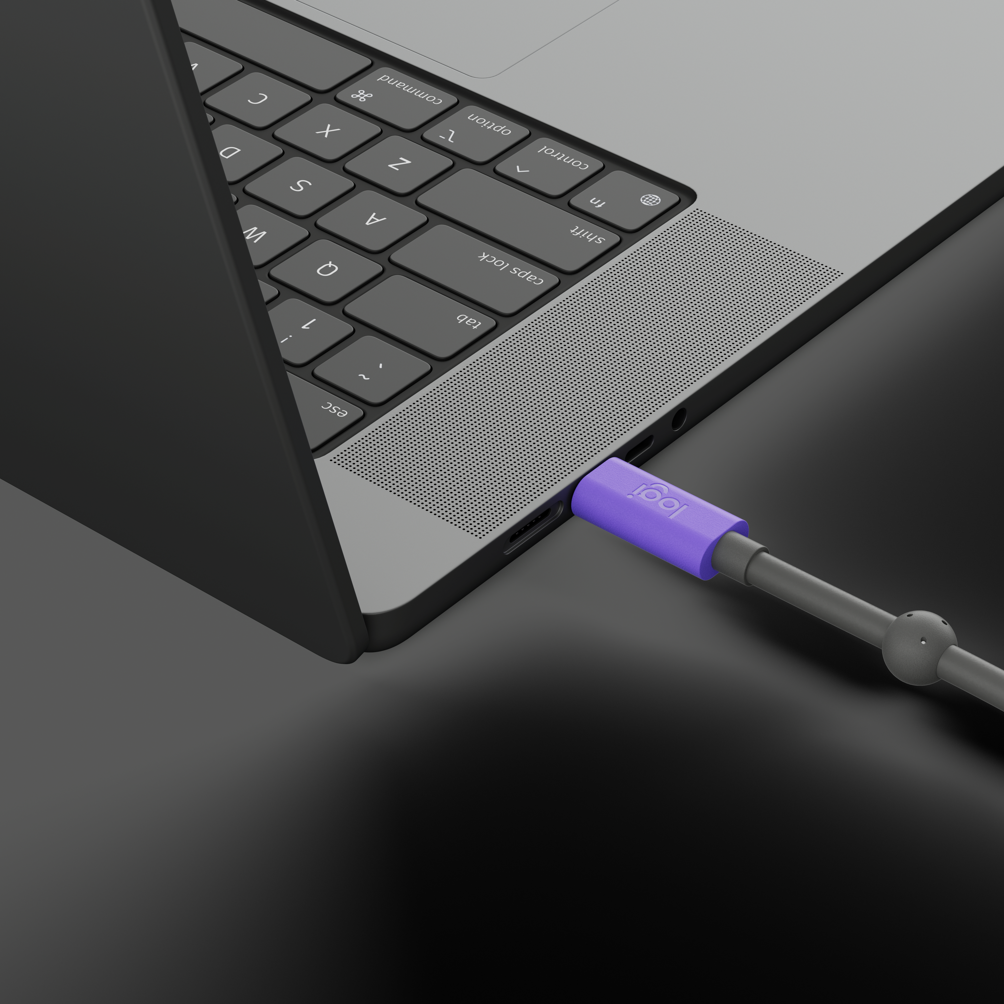 Laptop mit einem lila-grauen Kabel. Das Kabel ist an den Ladeanschluss des Laptops angeschlossen.