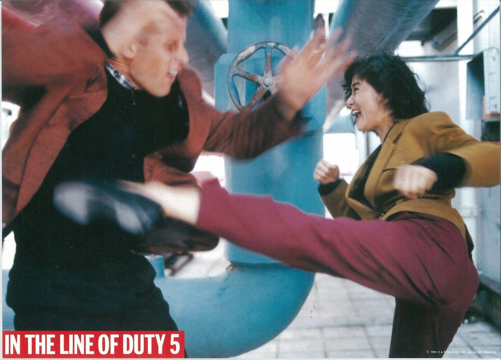 Zwei Personen in einer Actionszene. Einer tritt, der andere blockt. Sie stehen vor einem blauen Rohr. Text unten: In the Line of Duty 5.