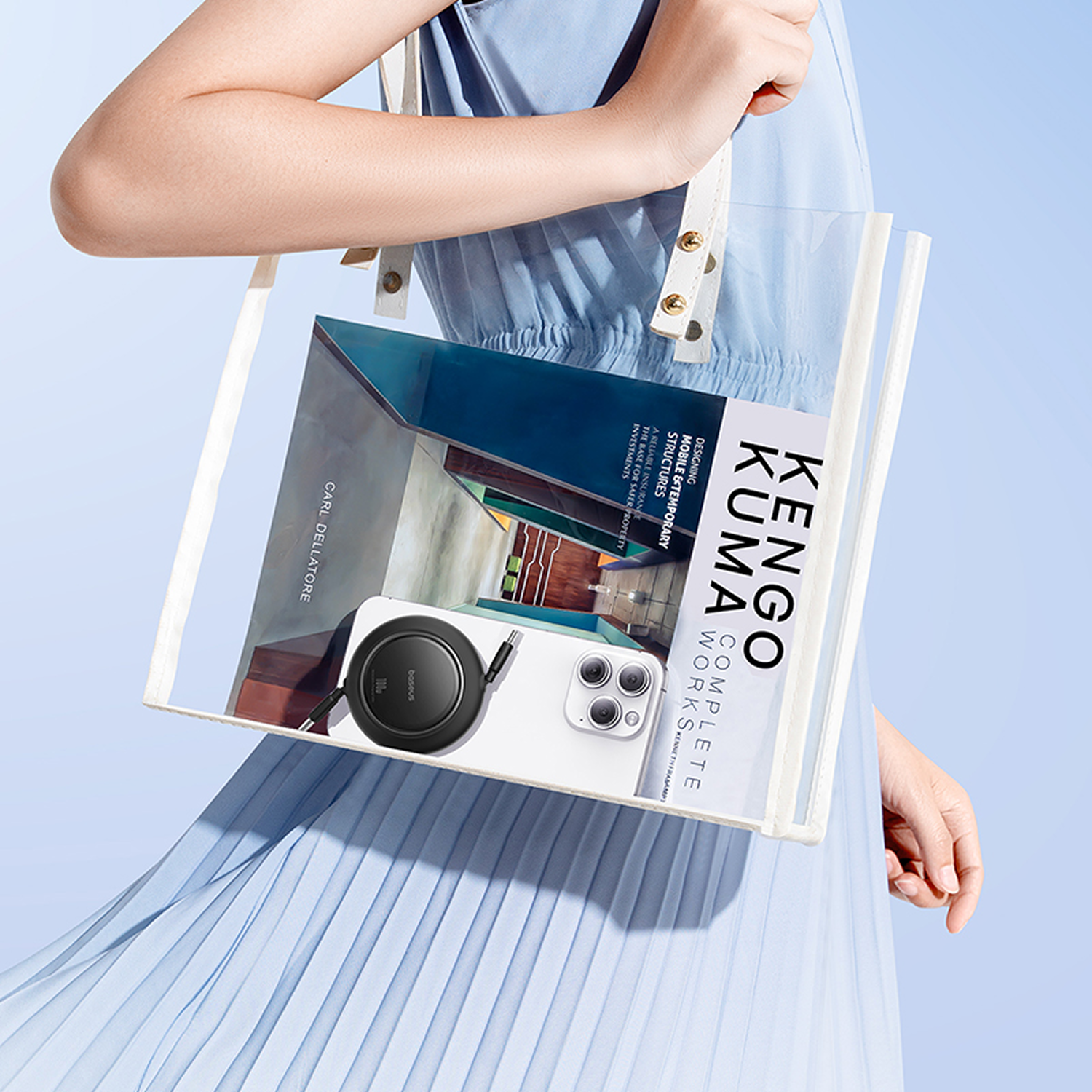 Una mujer con un vestido azul sostiene una bolsa transparente con un libro y un teléfono dentro. La bolsa contiene un cargador.