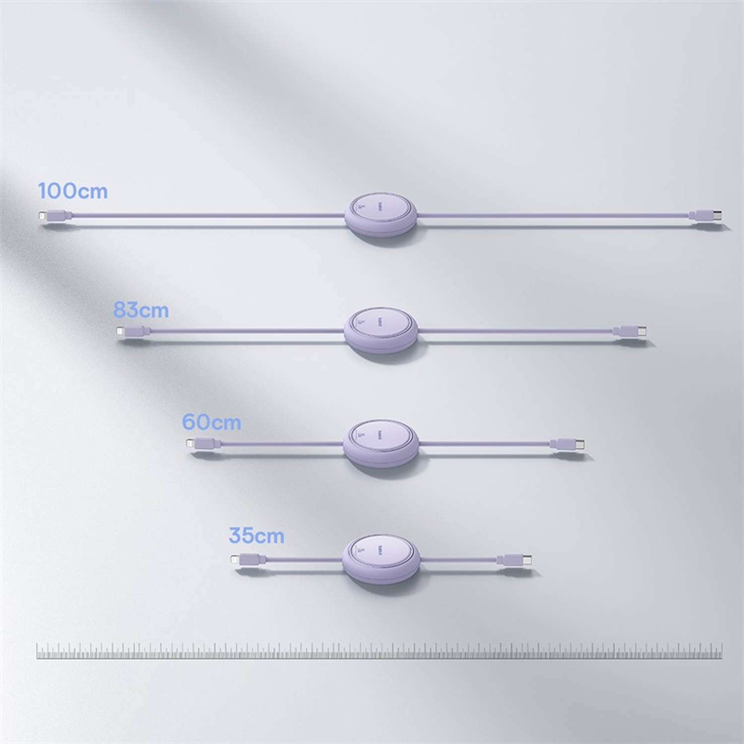 Cuatro cables de carga lilas de diferentes longitudes (100 cm, 83 cm, 60 cm, 35 cm) con una regla en la parte inferior, sobre un fondo gris claro.