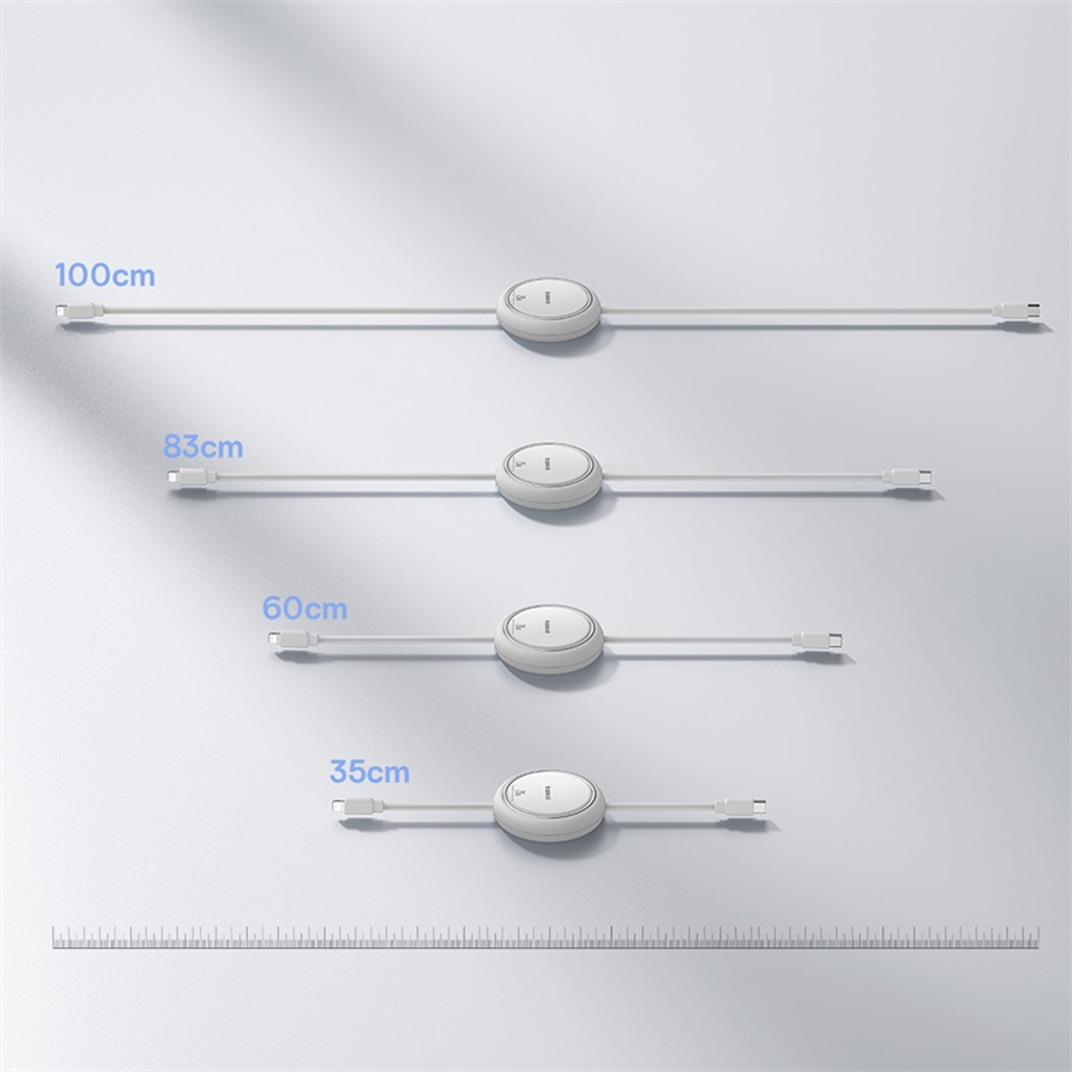Se muestran cuatro cables de carga blancos de diferentes longitudes, con etiquetas que indican sus longitudes. Una regla está en la parte inferior.